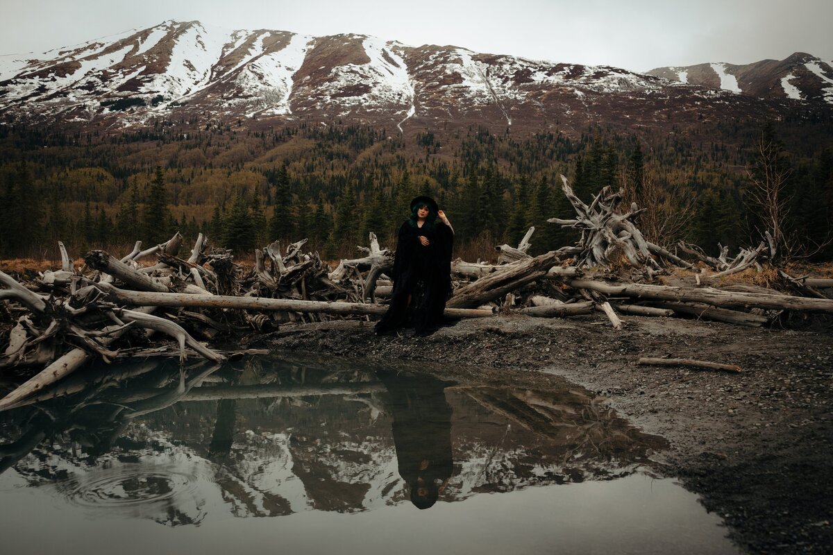 A non-traditional bride is photographed with her reflection in gorgeous alaskan wilderness