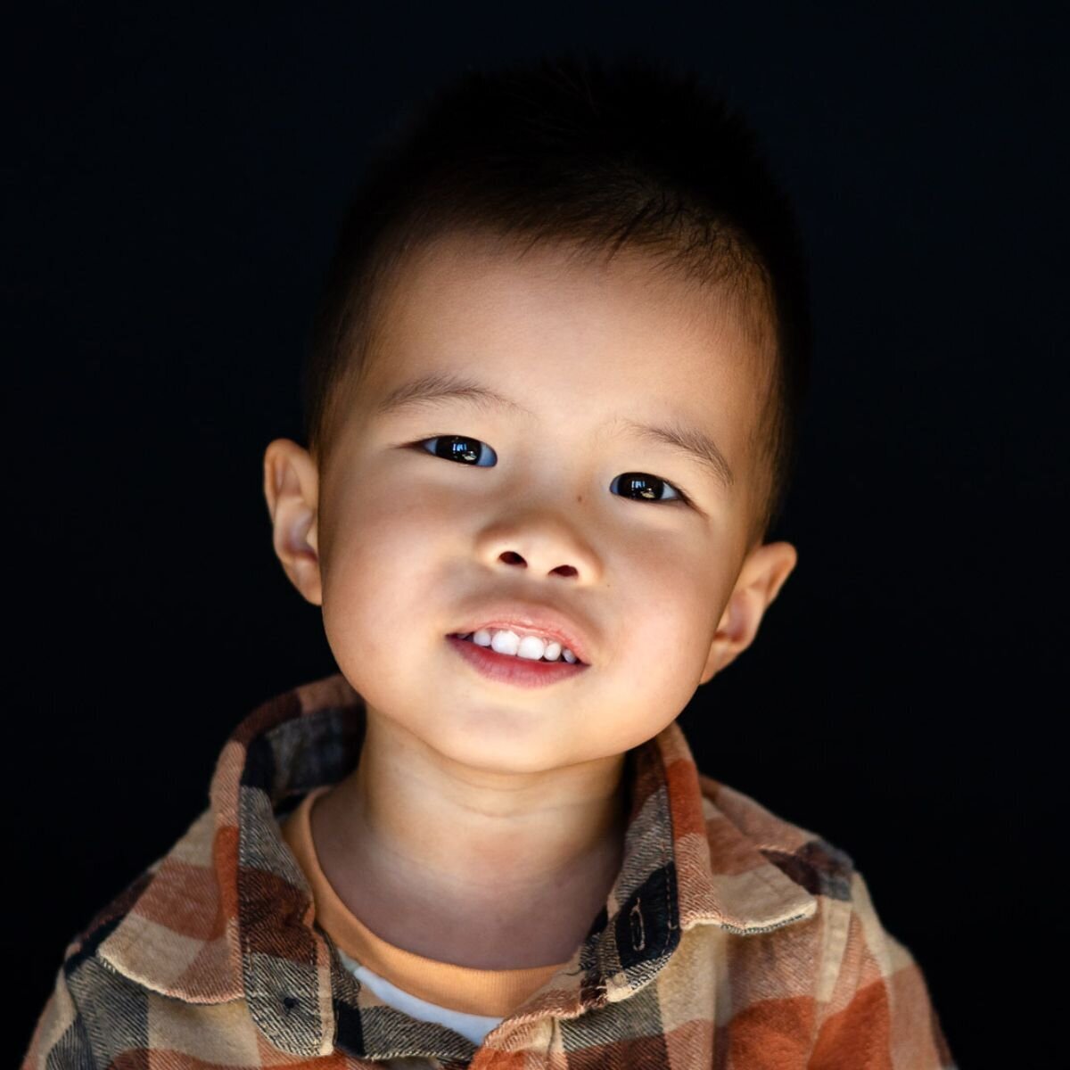 Young student smiling brightly against a dark background during Bay Area School Photography session – Ellobelle Photography