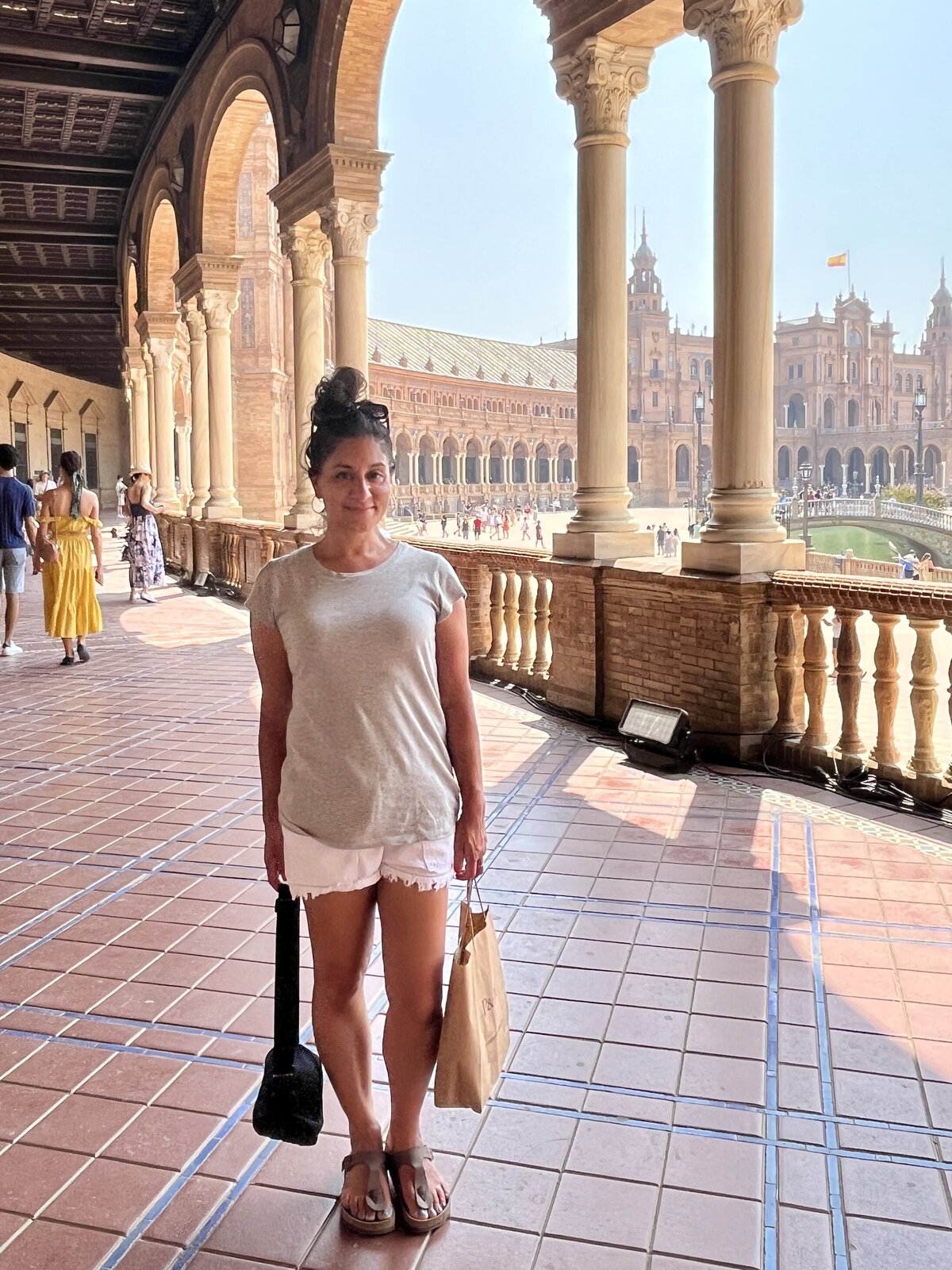 Sonia carrying bags while exploring a city on vacation