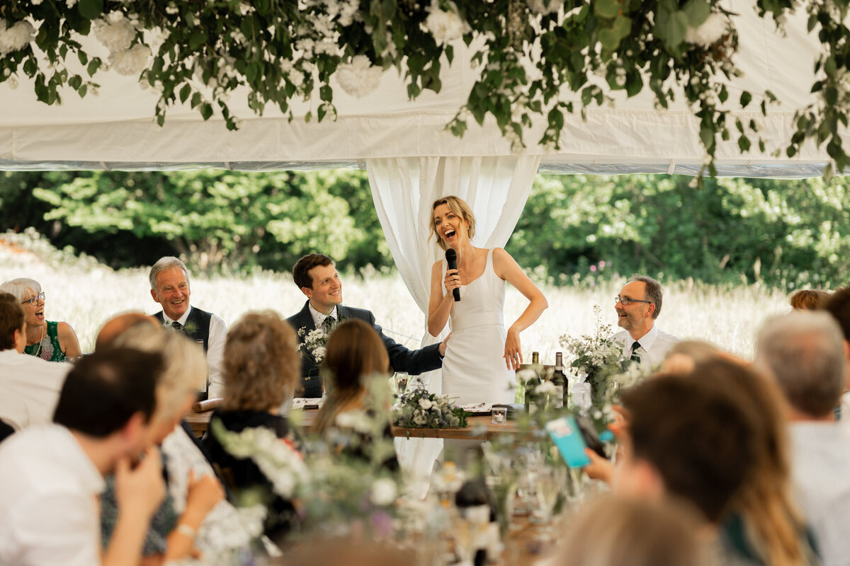 The bride gives a toast at Devon marquee wedding