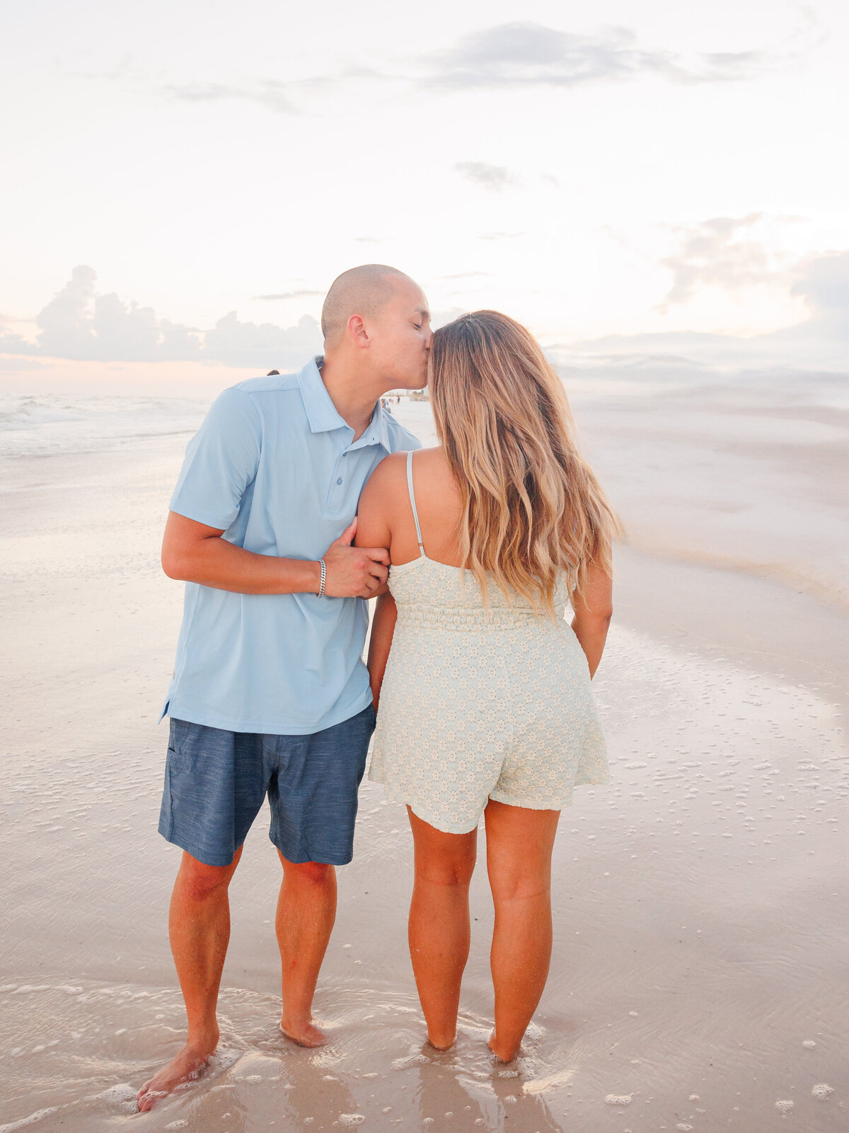 couple takes a few minutes from family session to have a sweet kiss on forehead