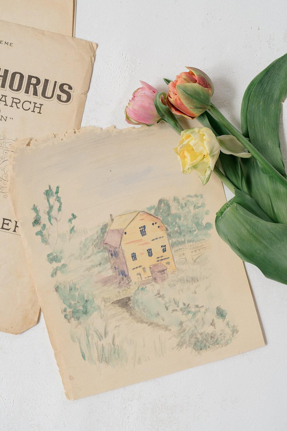 brand photos for a small business with a watercolor of a farm sitting on a table with flowers