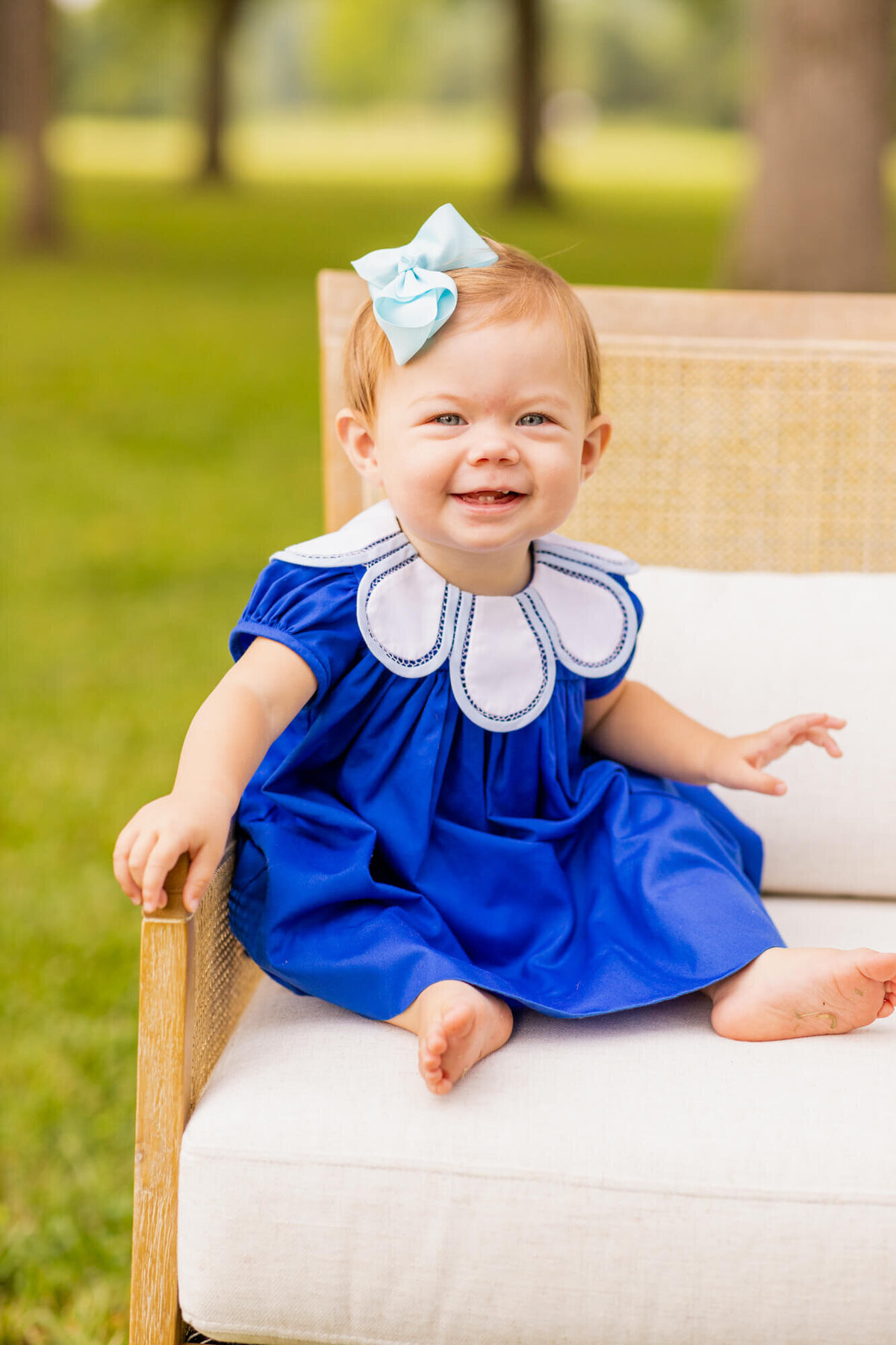 toddler girl sitting in a chair in a field