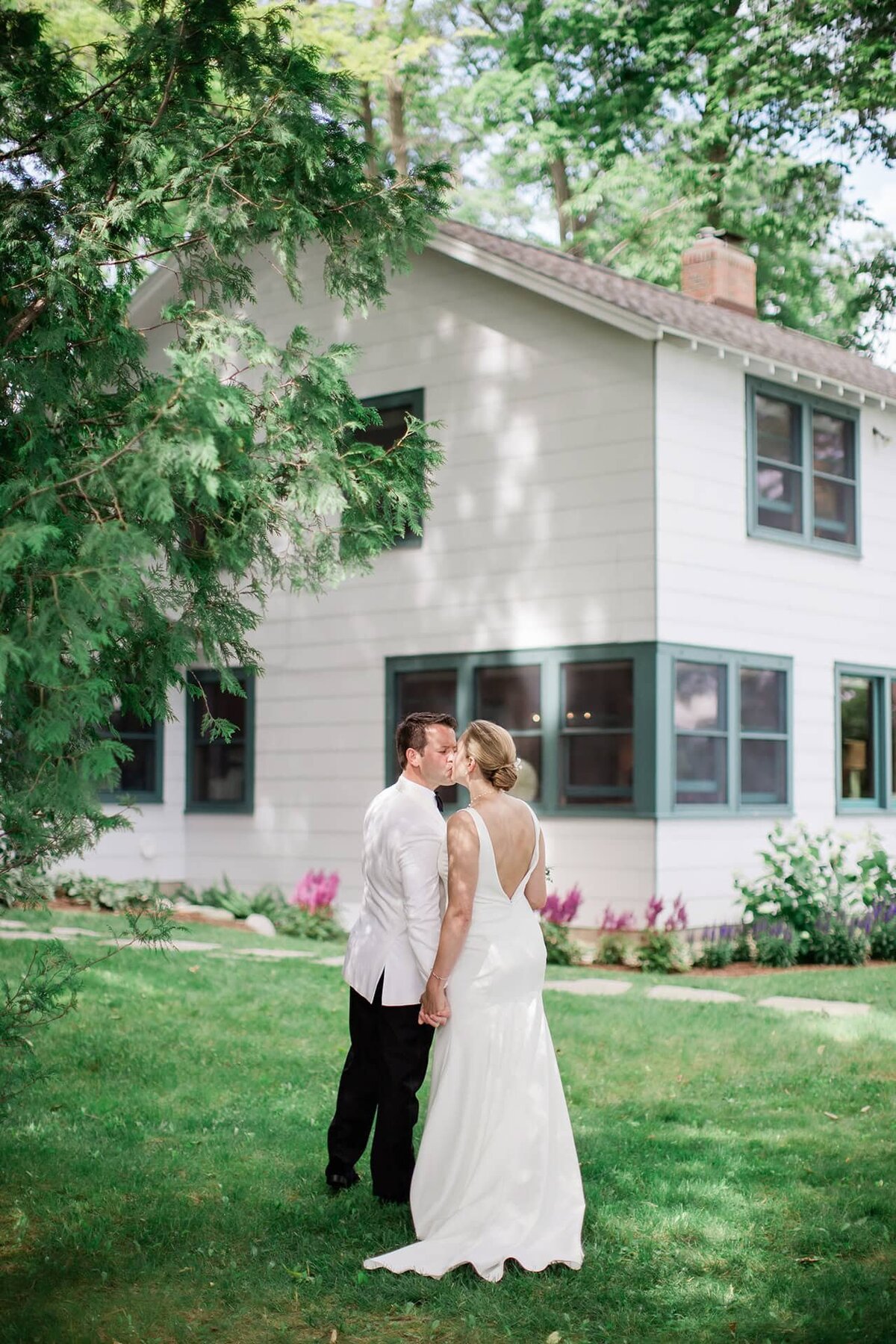 Couple kissing by family cabin for family residence wedding