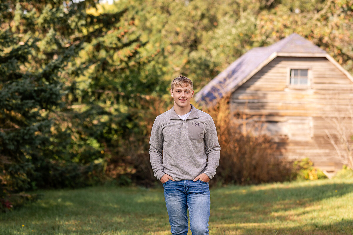 Senior guy walking  in front of an old rustic barn.