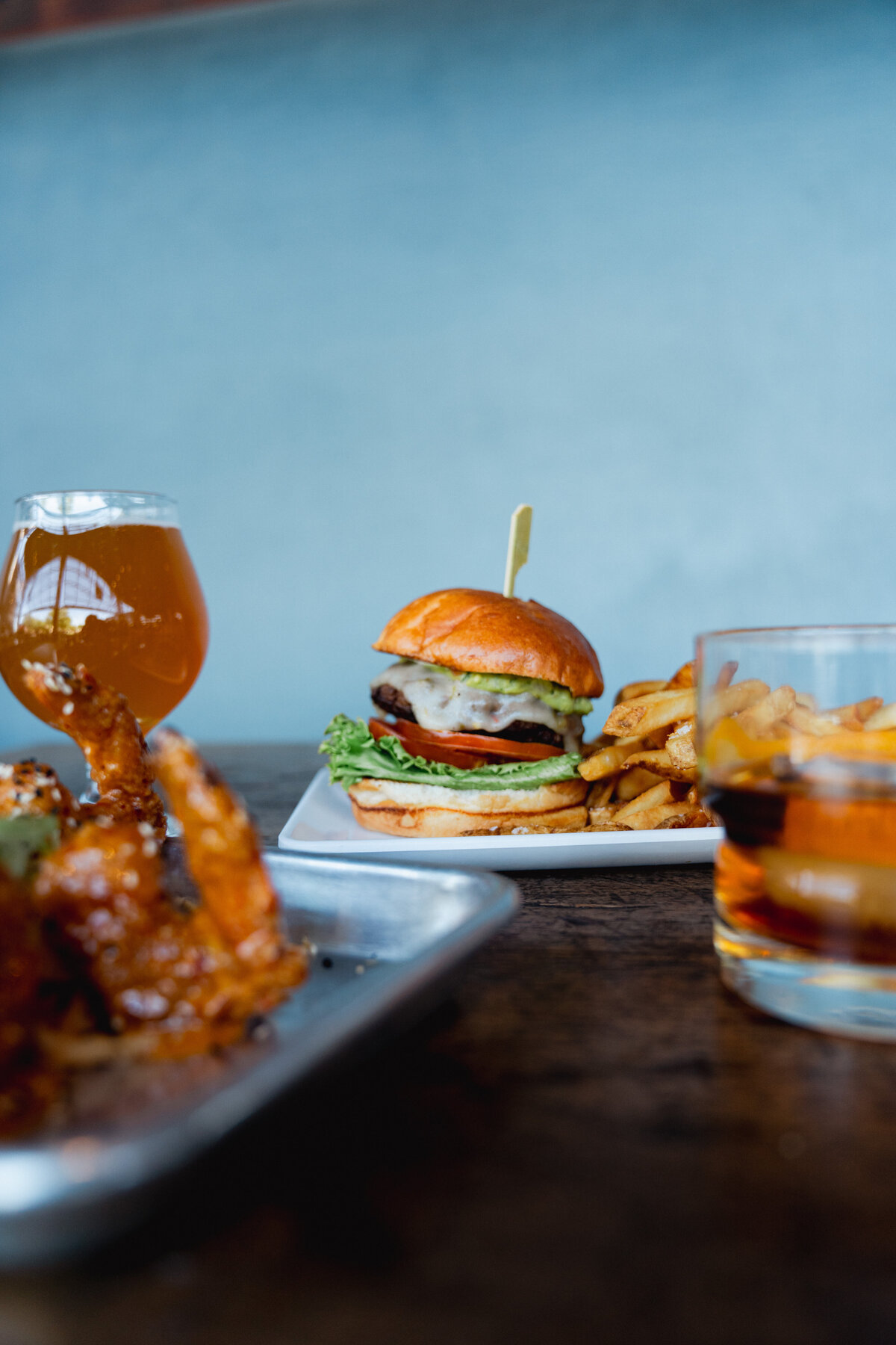 The Dust bowl brewing new burger with fries, an old fashioned, fried prawns and a beer glass.