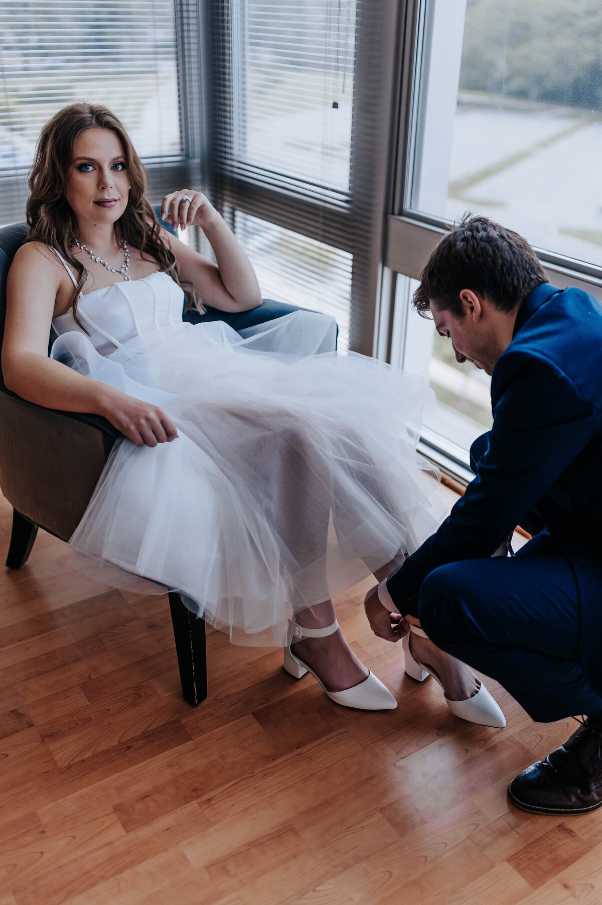 Destination elopement photographer captures groom putting on bride's shoes