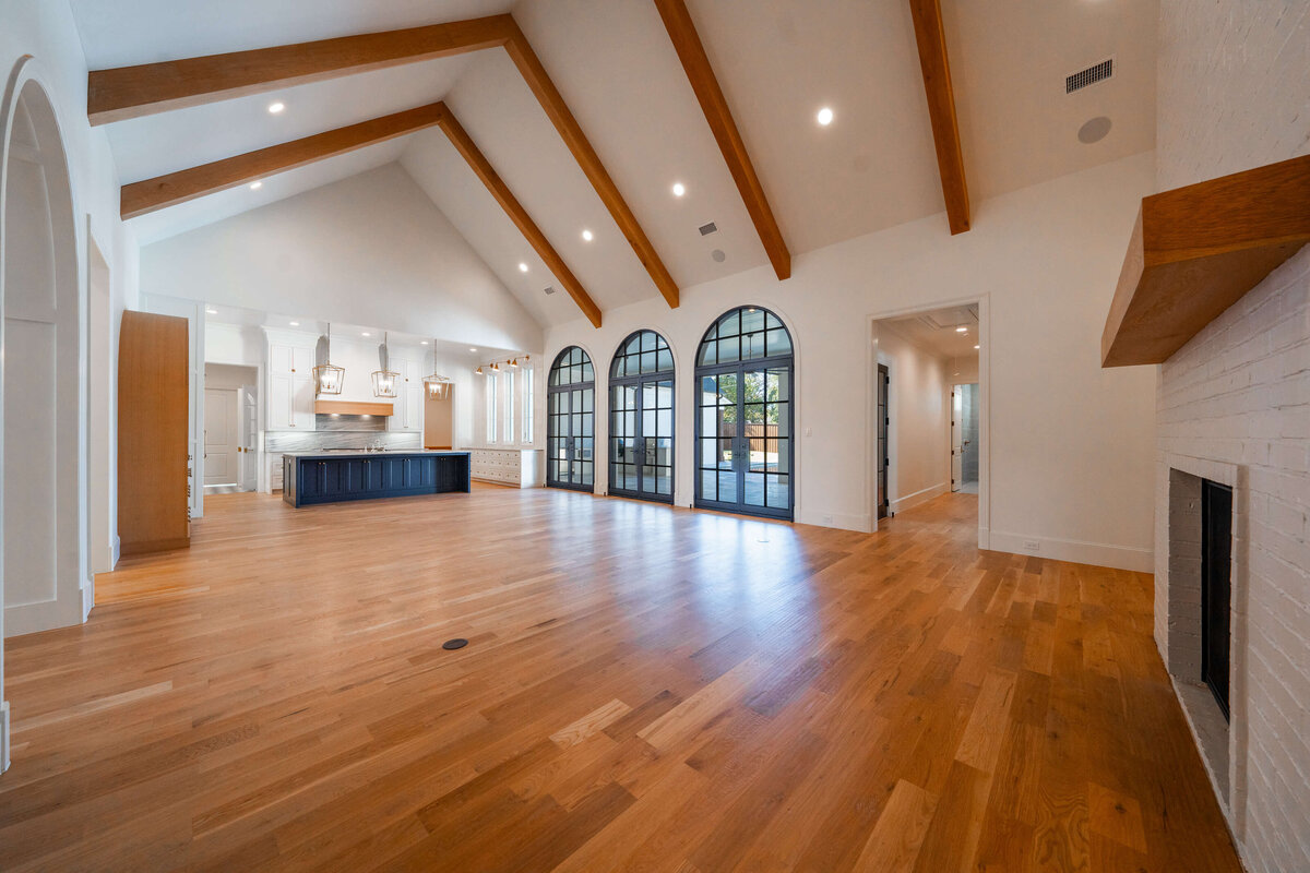 Open concept living area with cathedral ceiling and arched doors