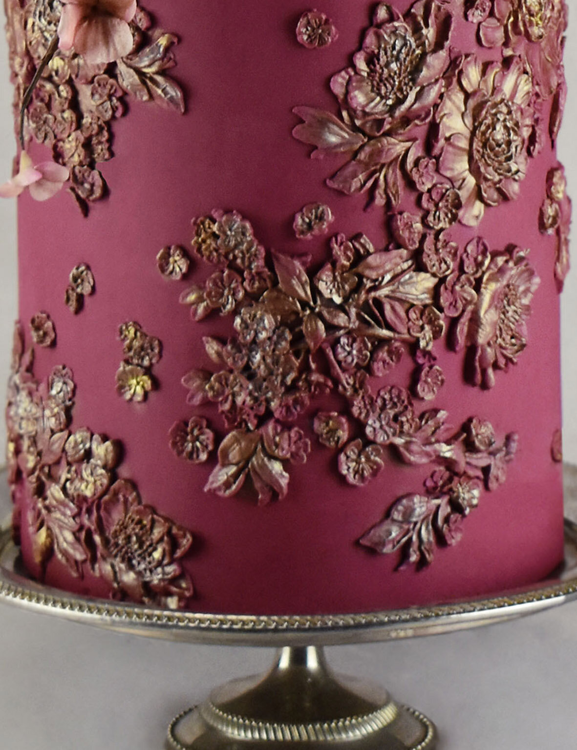 Bas relief floral detail on a burgundy wedding cake