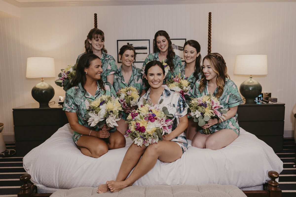 Bridal party smiling on a bed