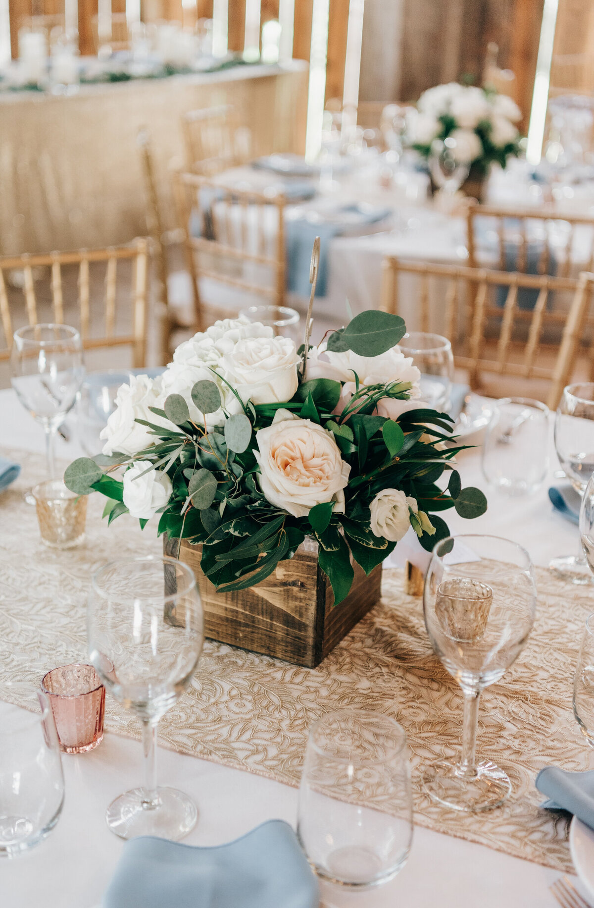 Elegant pink and white roses and eucalyptus centrepieces at glamorous barn wedding reception