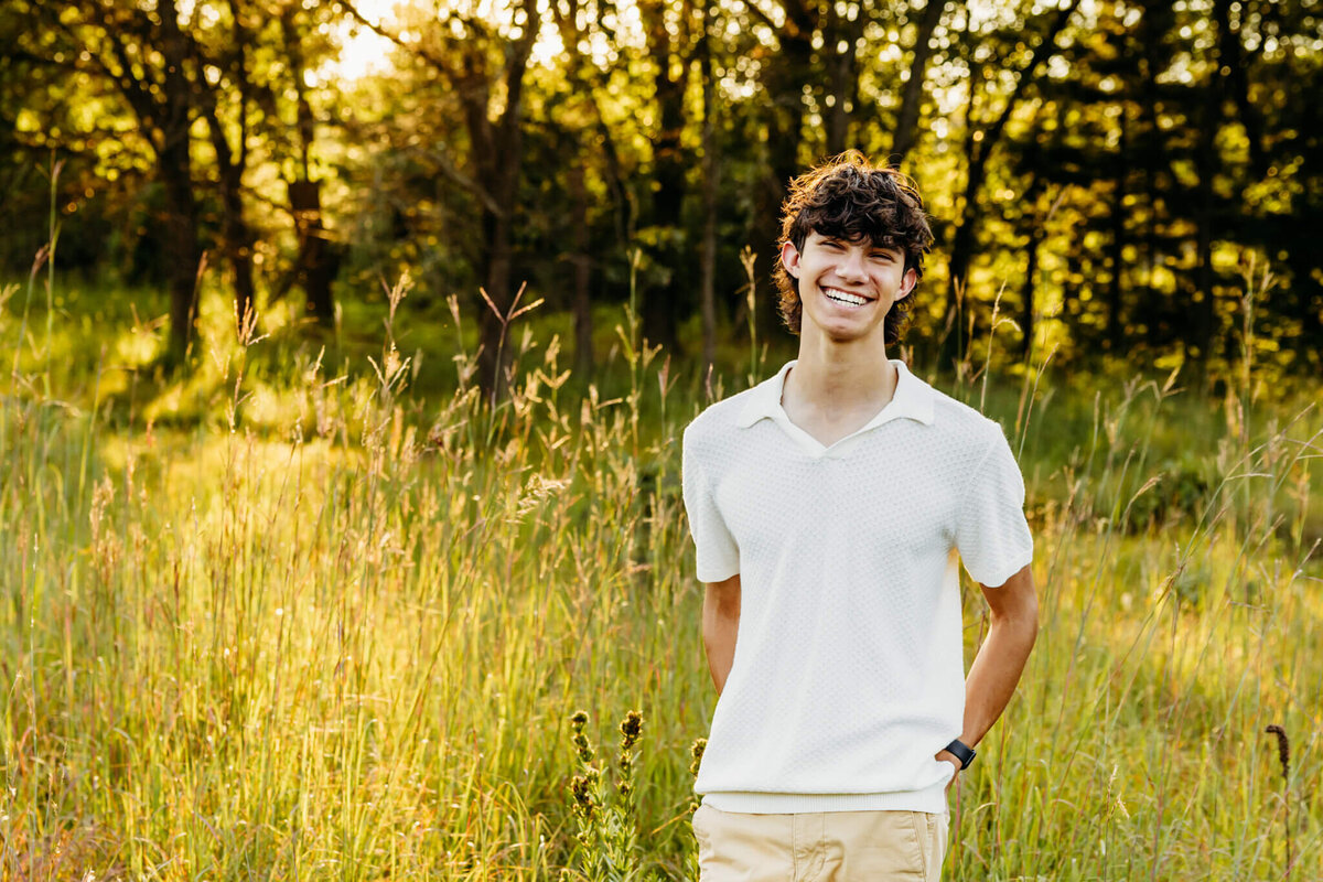 handsome teen boy from Green Bay high school laughing with both his hands in his back pocket. 