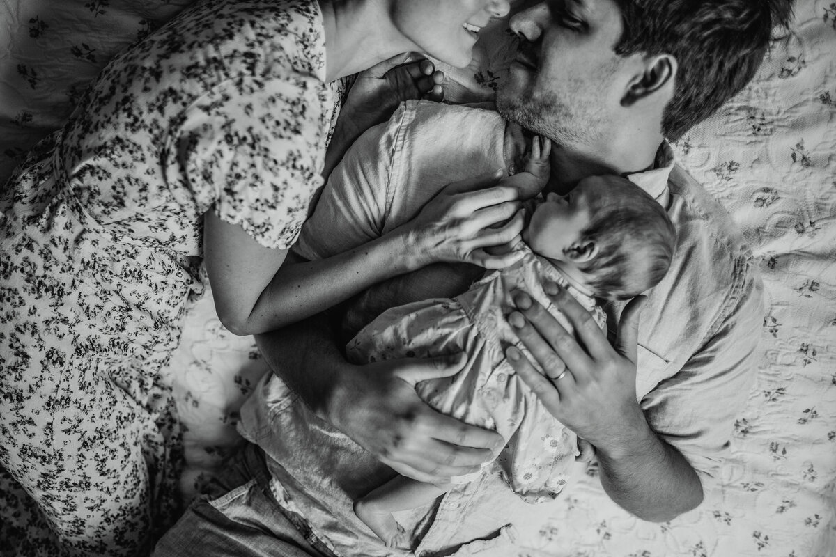 Moody family snuggles at  in-home lifestyle newborn photoshoot.