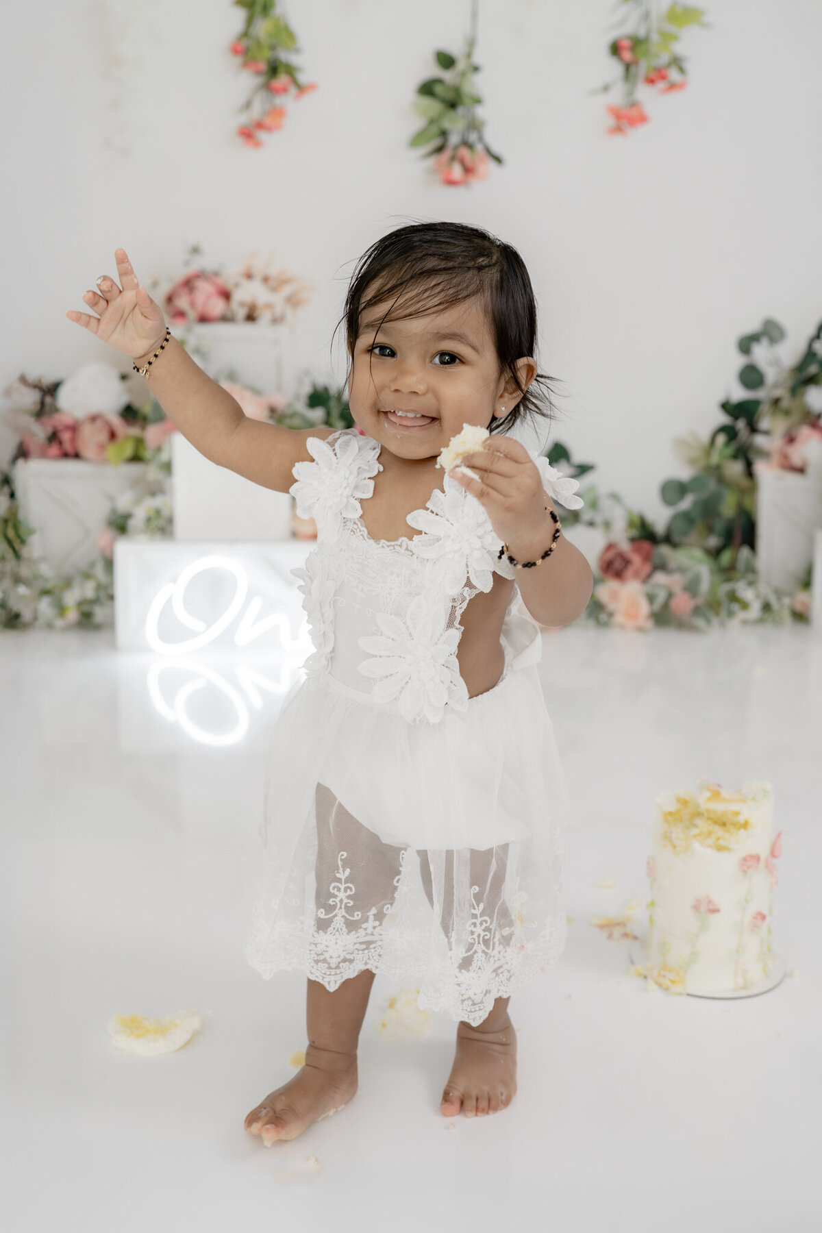 Girl eating cake during floral themed cake smash session— captured by Alliston and Barrie cake smash photographer.