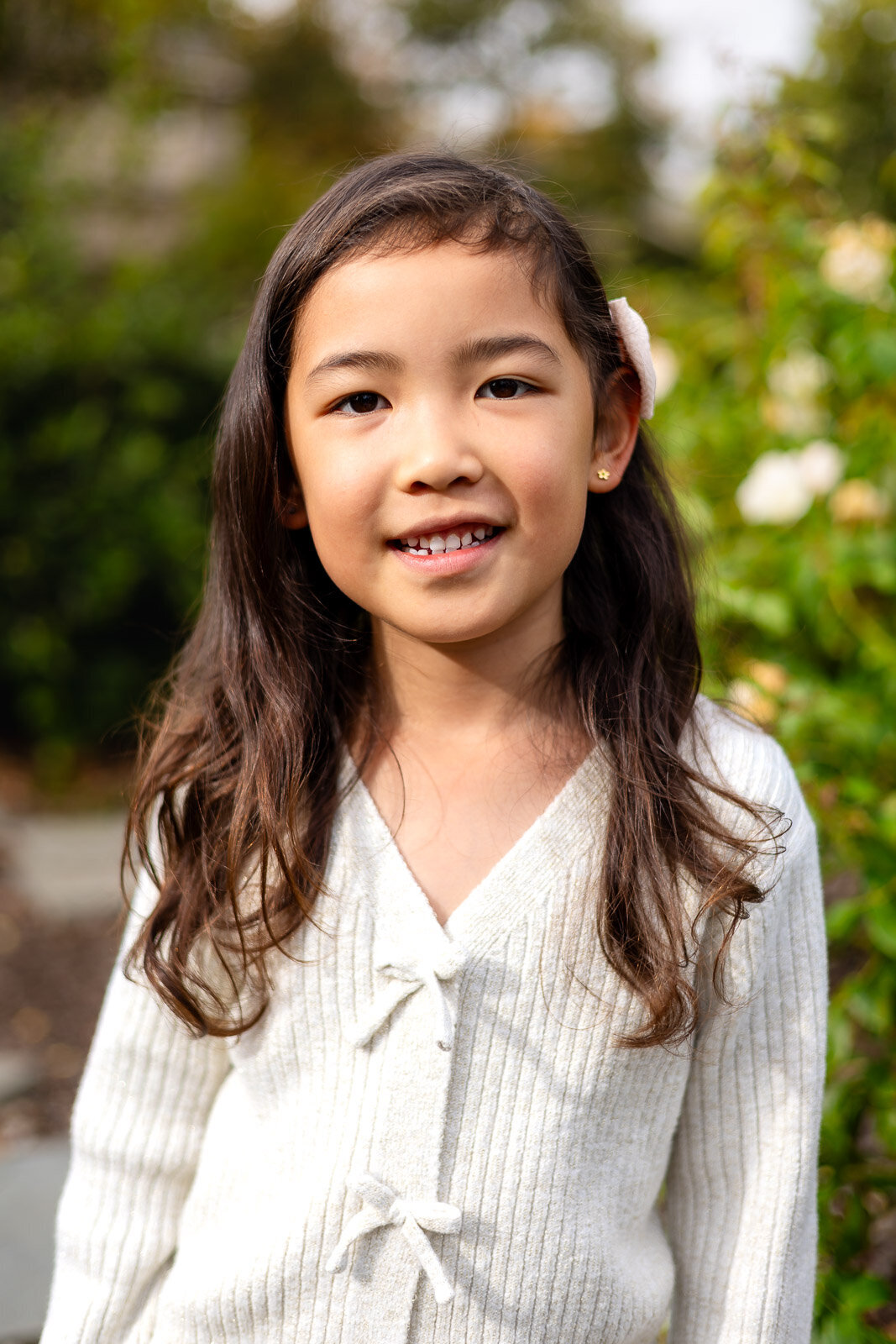 Young girl smiling among roses during Bay Area school photography lifestyle session – Ellobelle Photography