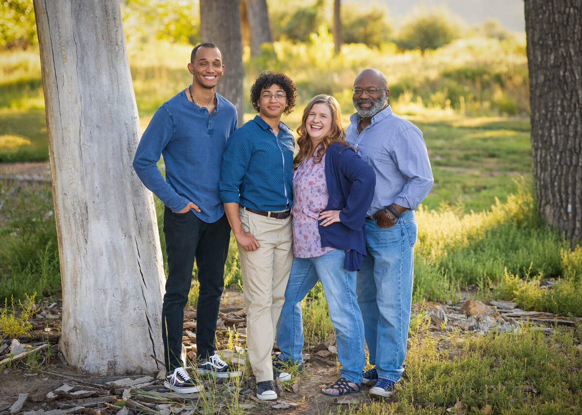 family of four standing together in a field