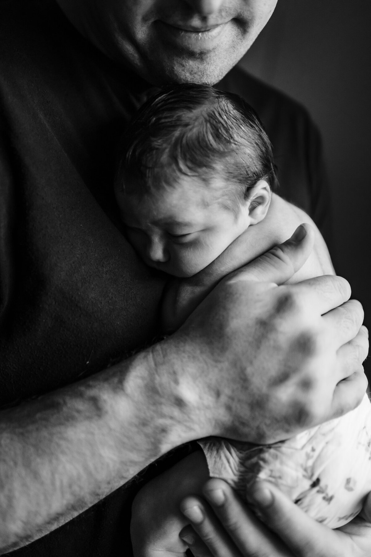 monochromatic newborn photos. Baby in dads big hands