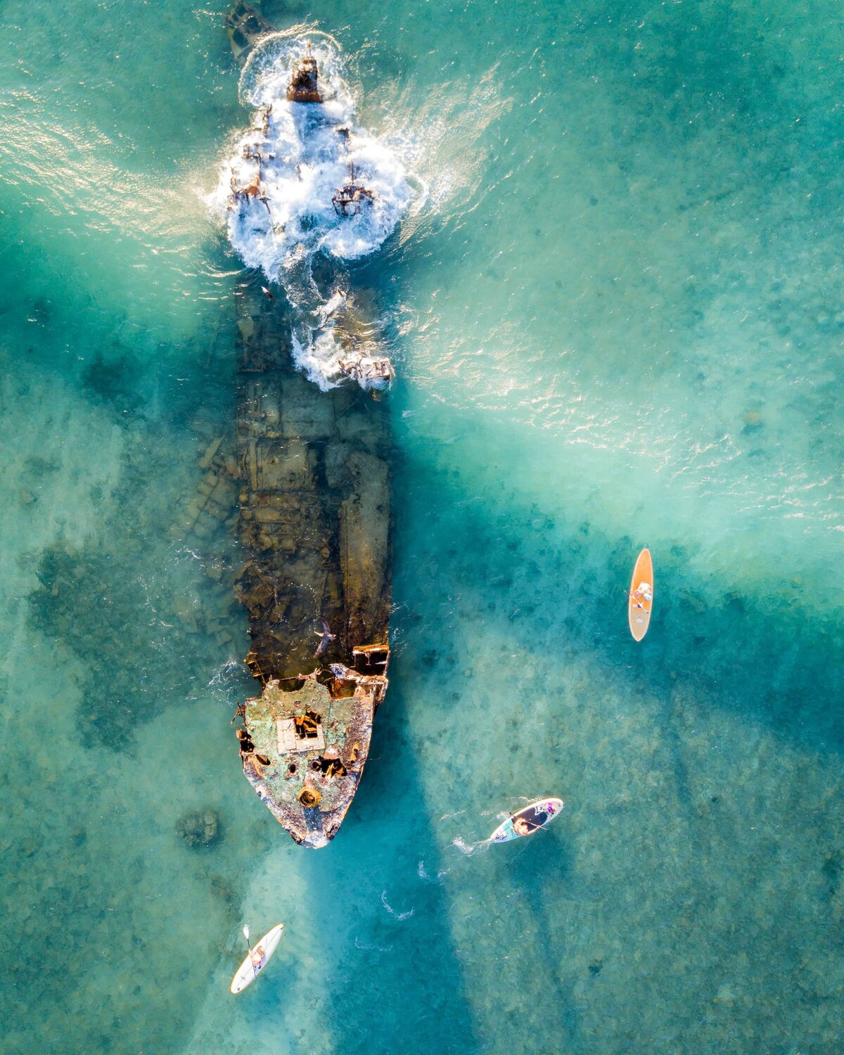 Aerial view of sunken ship in Aruba with three kayaks around it