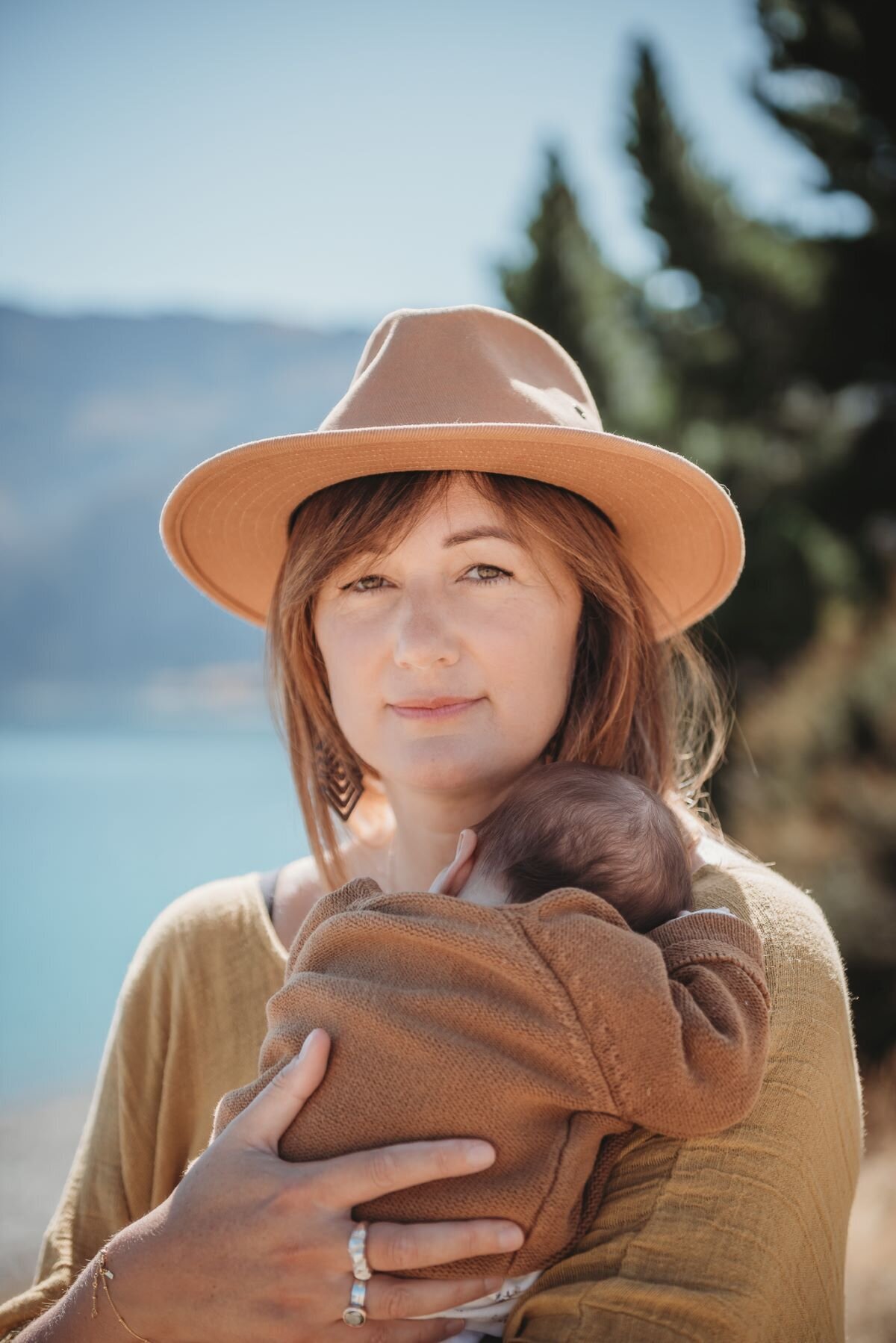 a mum holding her newborn baby during a photo session in wanaka