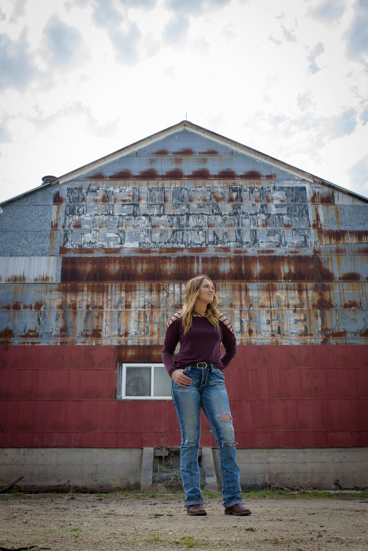 Denmark Senior Girl wearing maroon shirt standing in front of Bellevue Feed Mill in Green Bay, Wisconsin