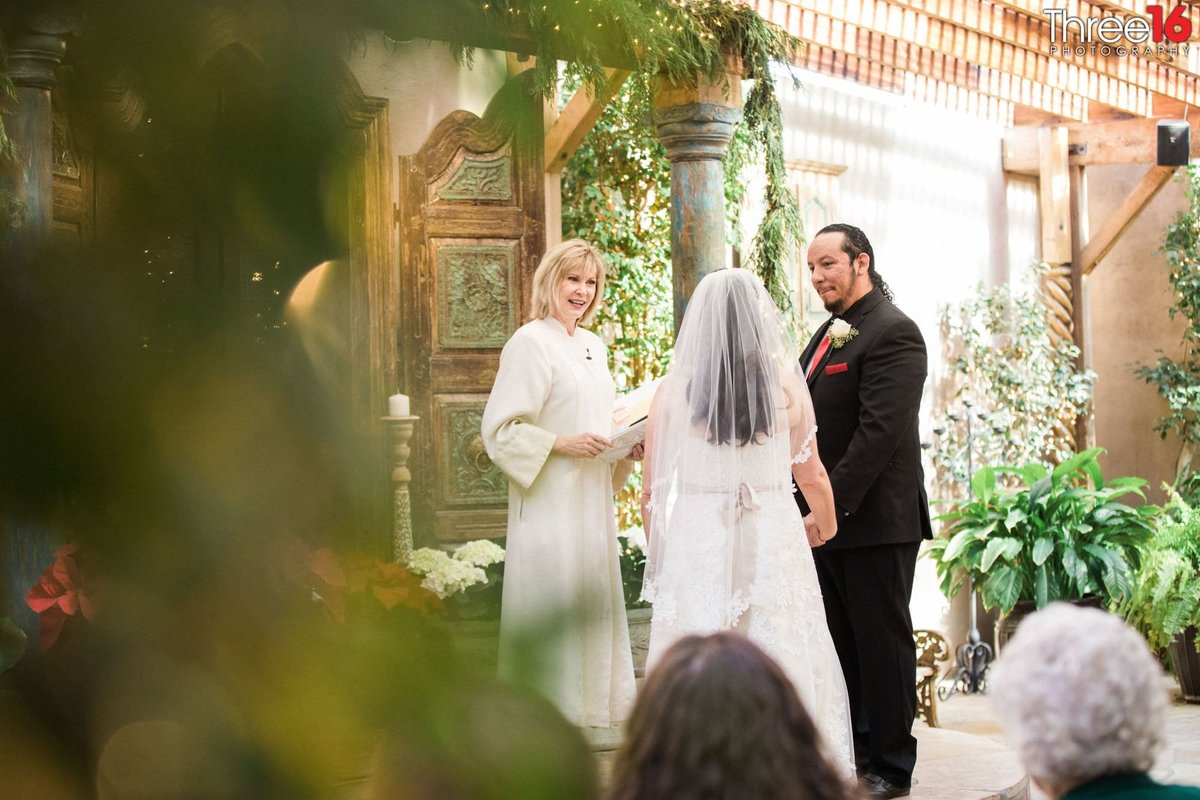 Officiant delivers the wedding vows to Bride and Groom at the altar
