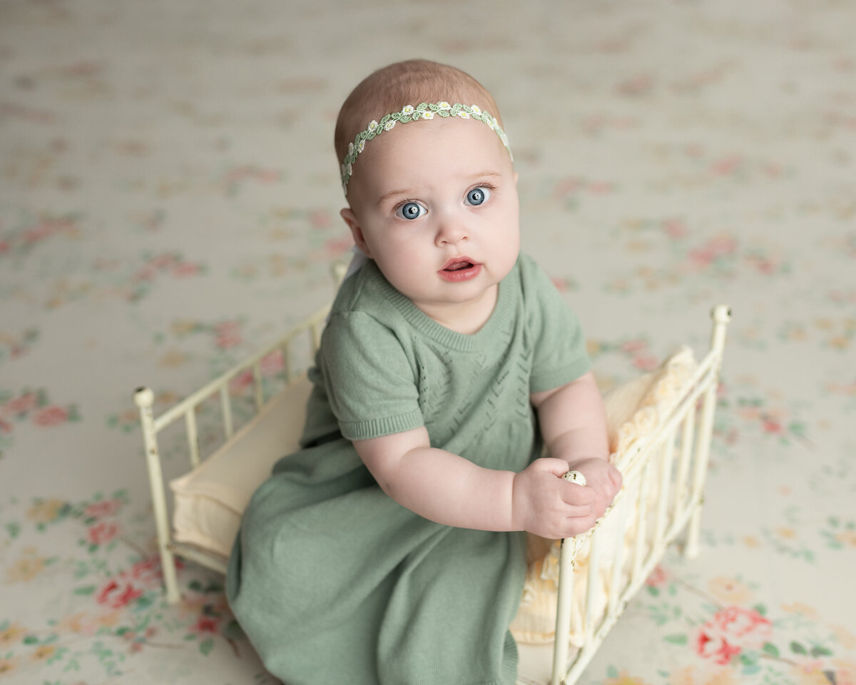 Milestone baby girl session in Paris, Ontario, featuring floral styling, a sage green dress, and a dainty vintage setup.