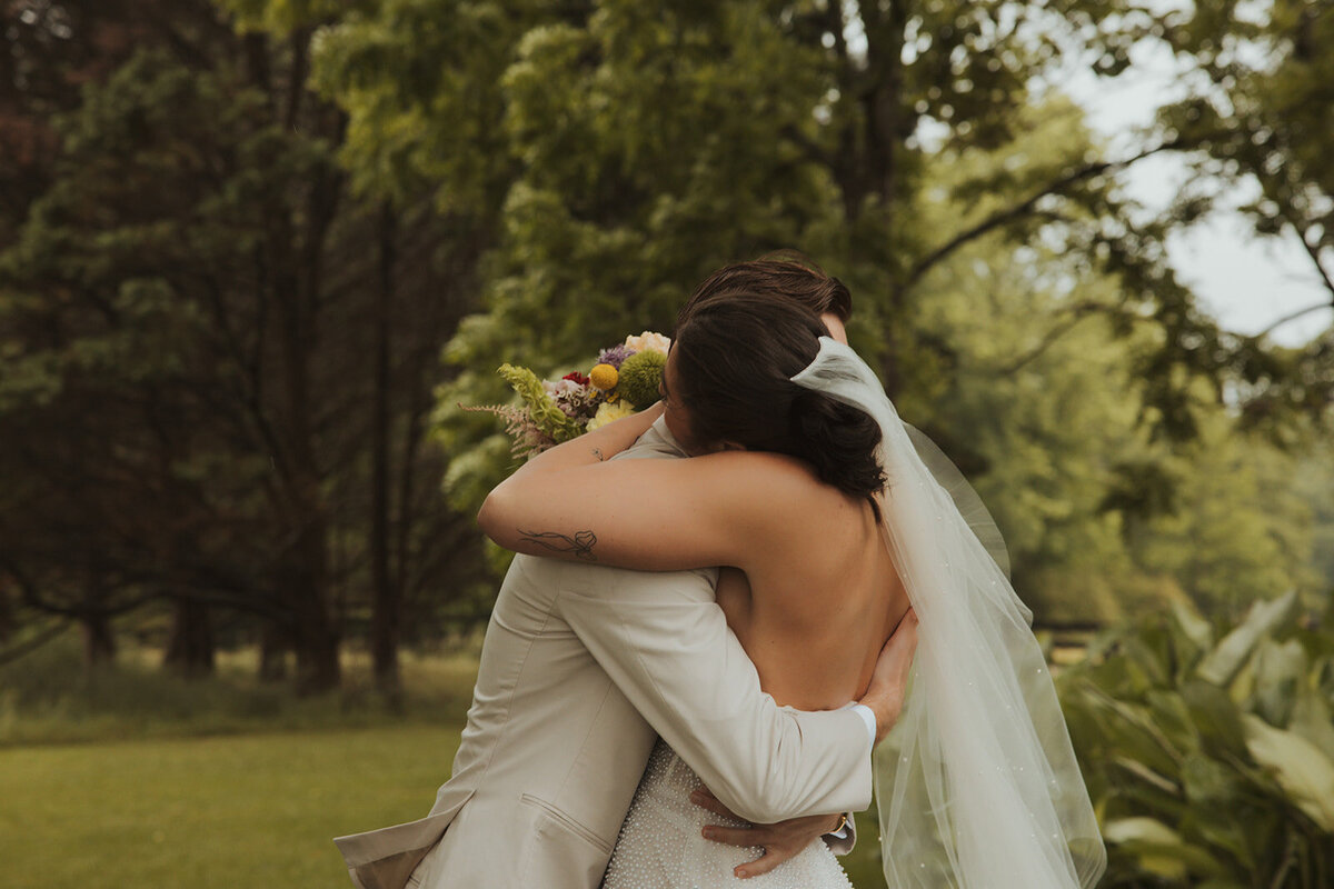 Bride and groom embracing in a hug for their first look
