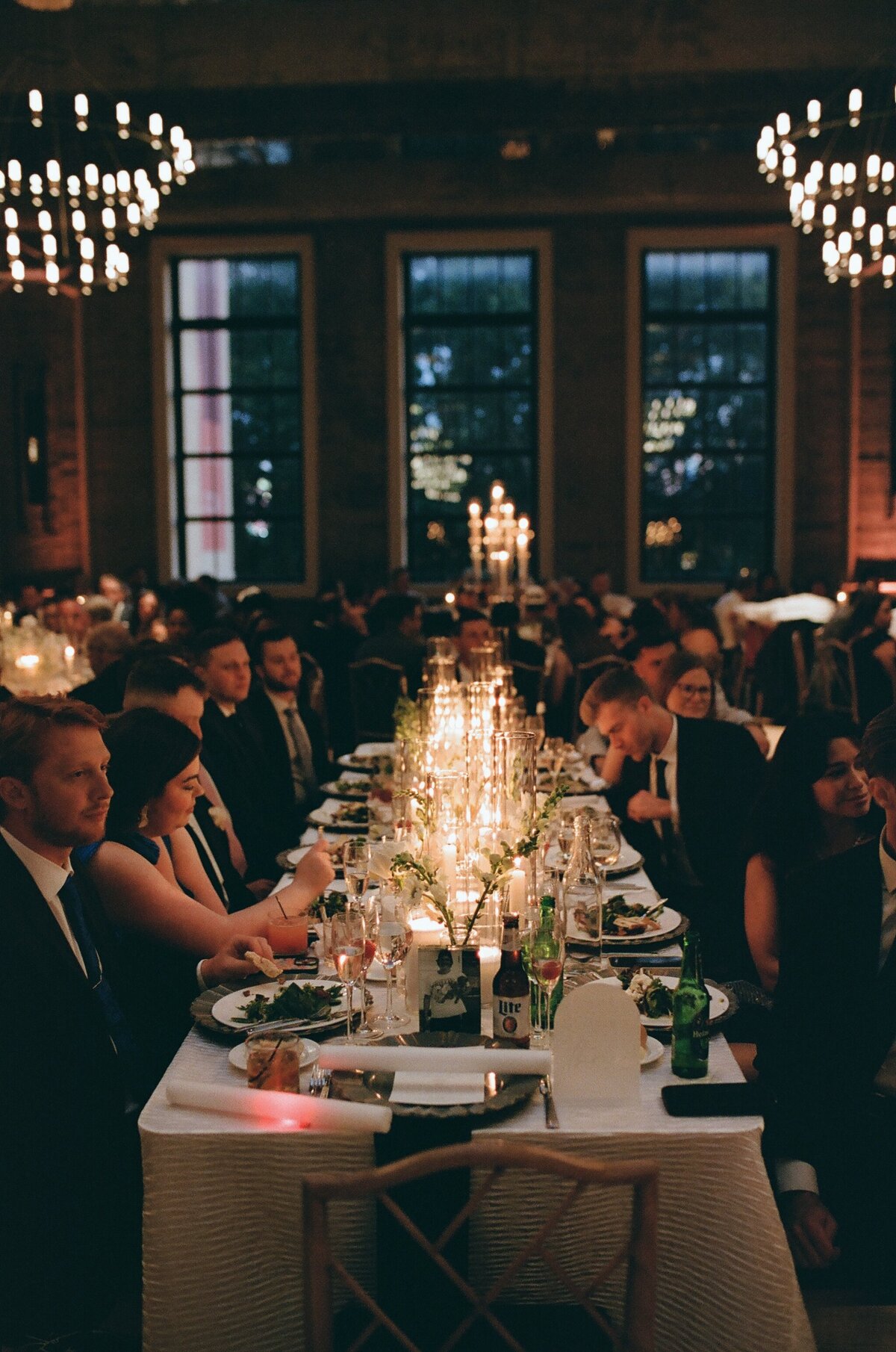 a couple walking through a forest together. He is leading her while she holds his hand and laughs. 
