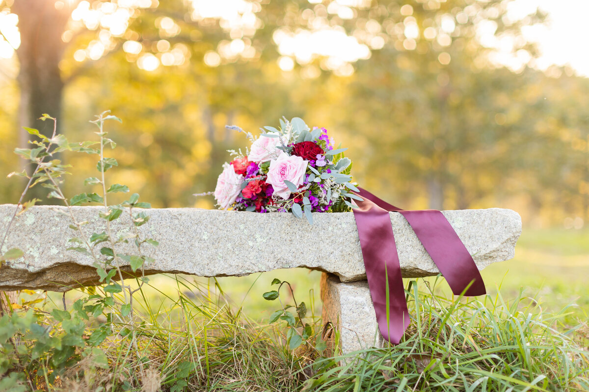 Flowers on a stone bench taken outdoors by Tiffany McFalls.