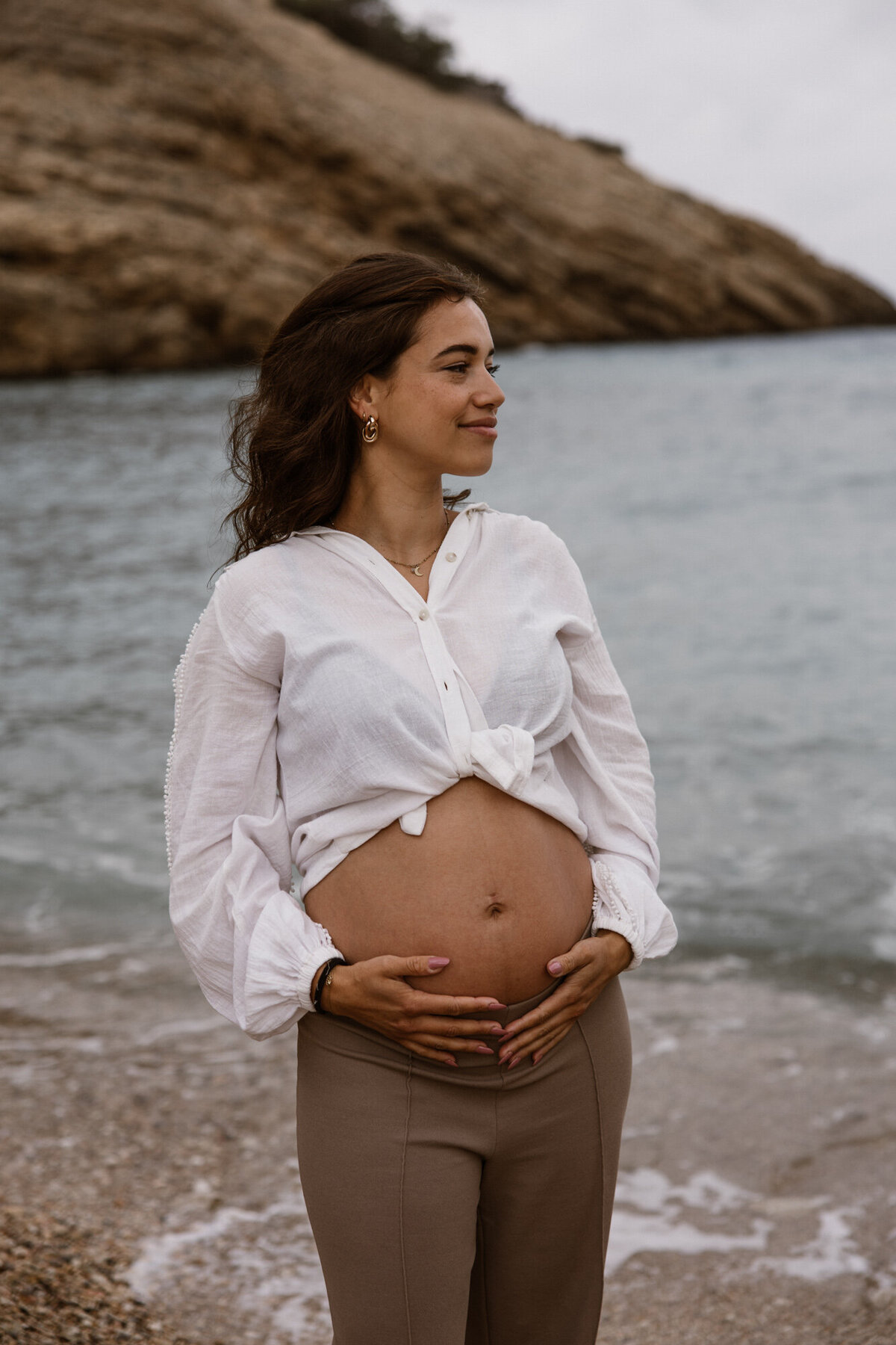 Woman is posing in front of the sea on Ibiza during a pregnancy photoshoot