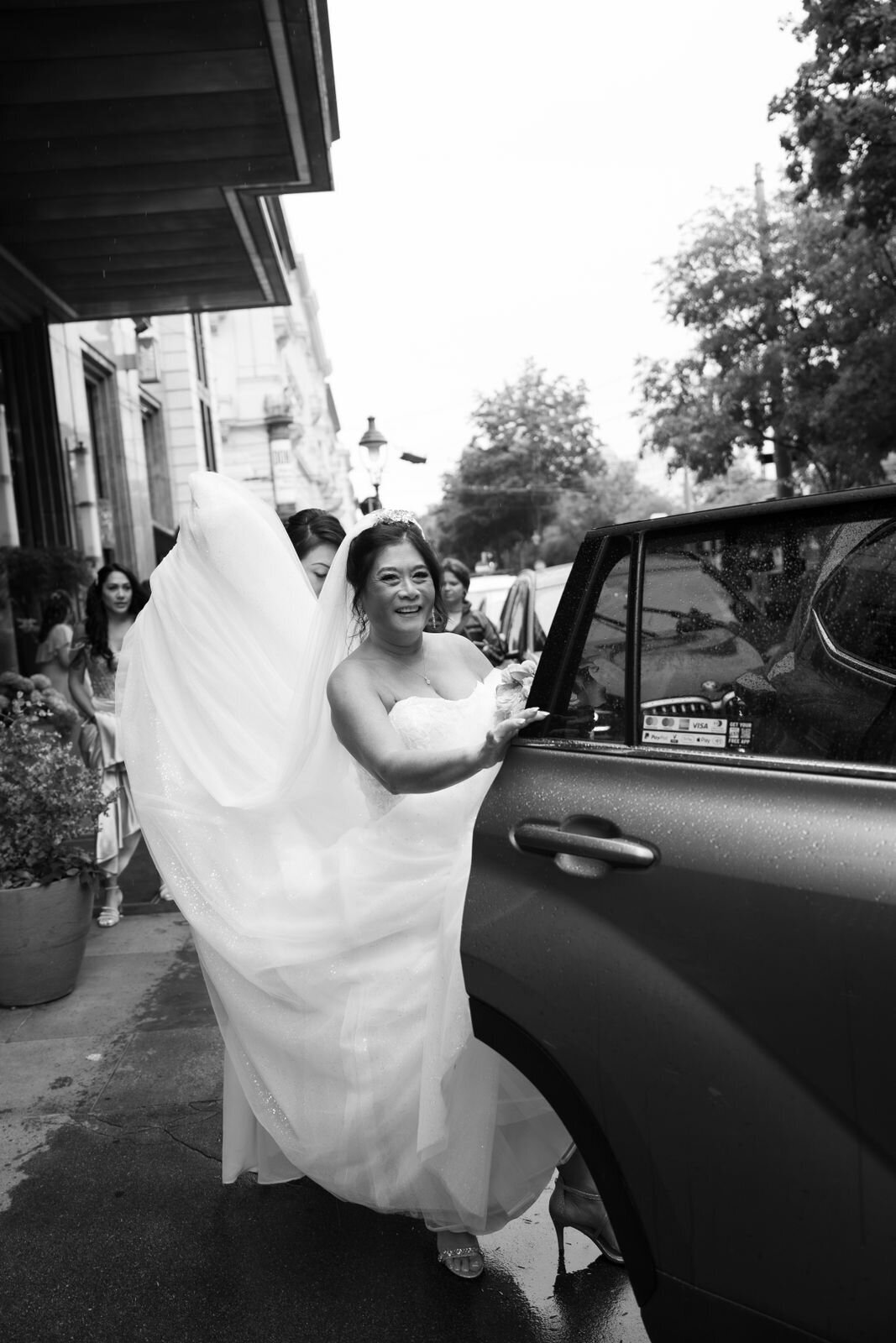 Bride and her bridal party entering her bridal car at luxury wedding palace Daun Kinsky