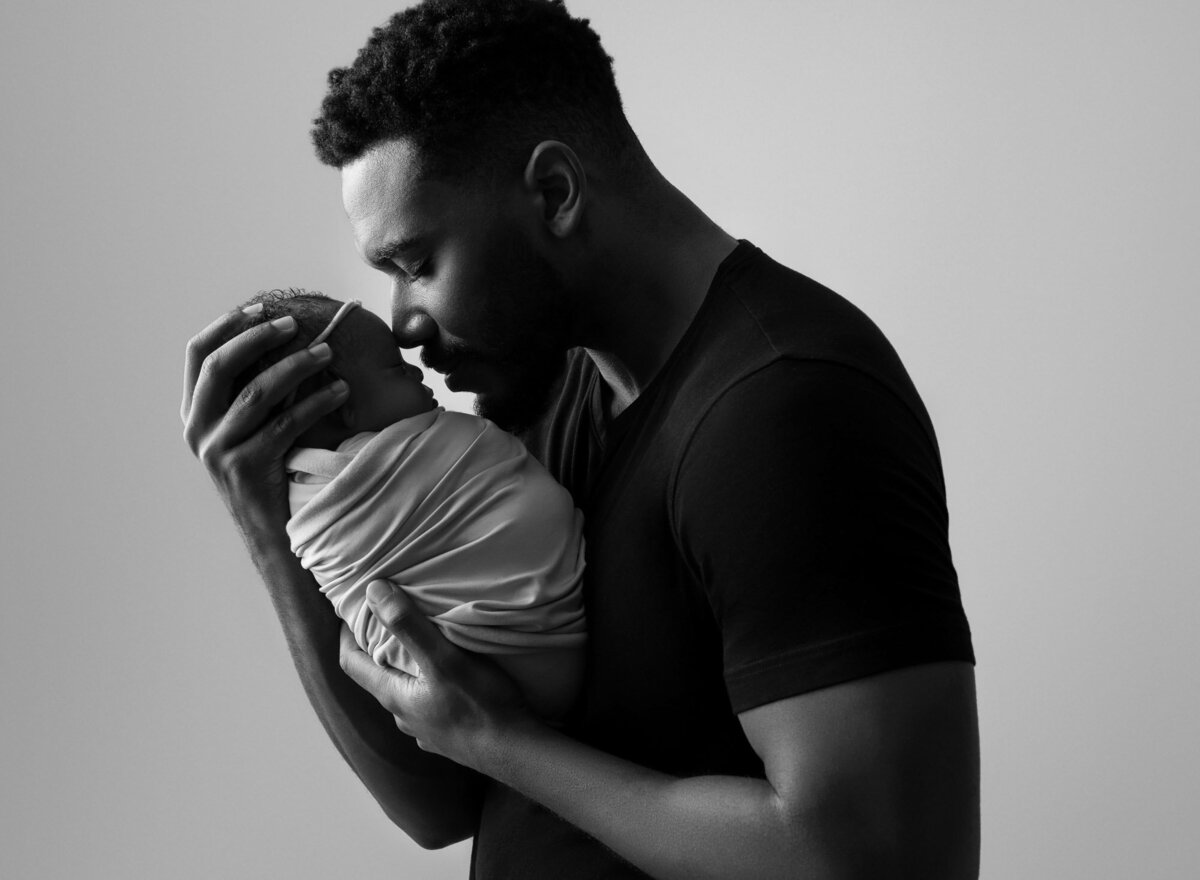 Black white father holding newborn baby Liberty Hill family photographer