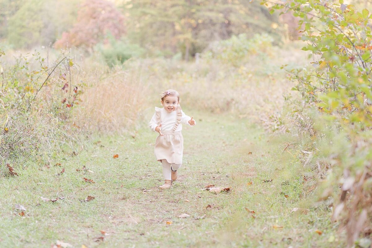 little girl running during fall minis taken by an Ashburn, Virginia photographer