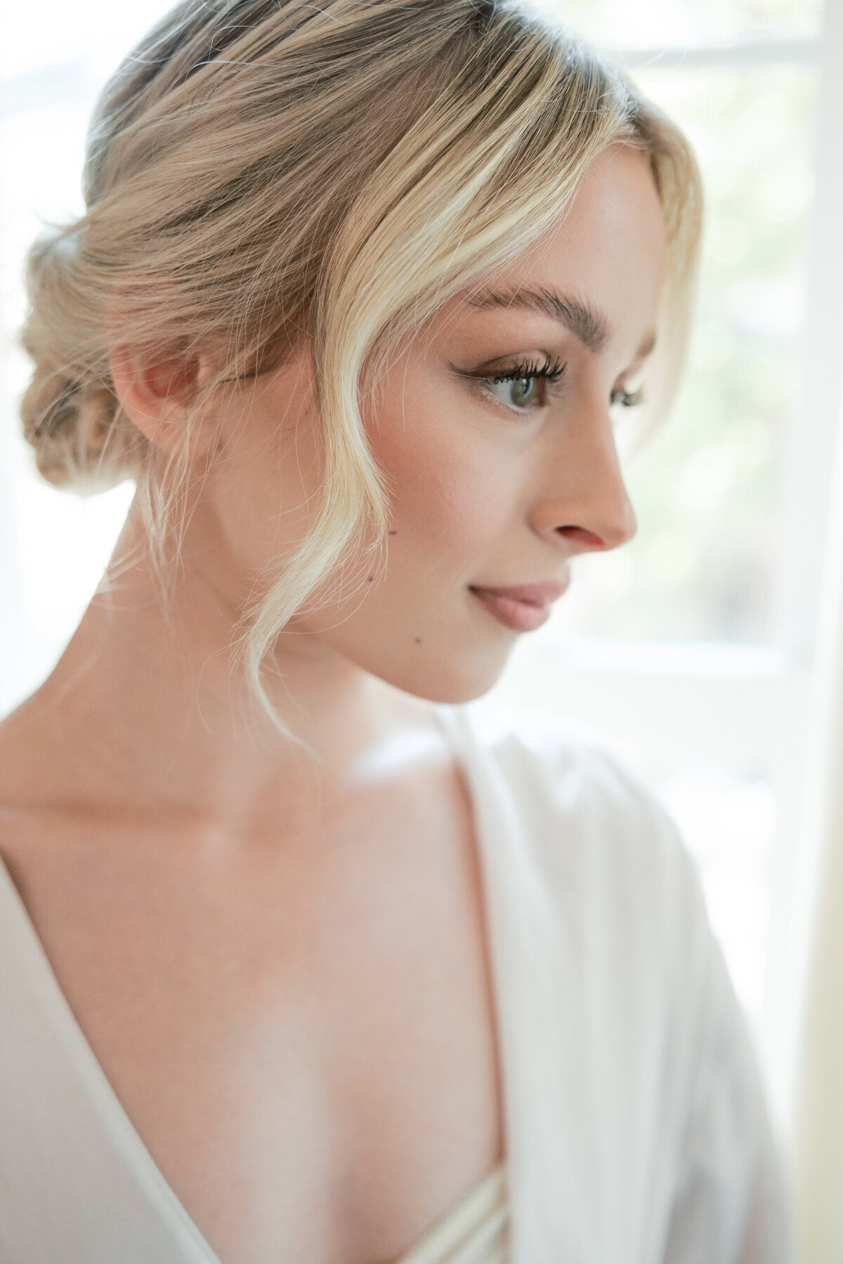 Close-up of bride’s glowing makeup and hairstyle in natural light, taken in Dayton by a Philadelphia wedding photographer.