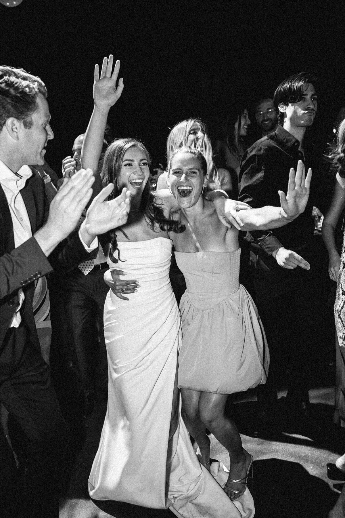 Bride and guests dancing energetically at a wedding reception