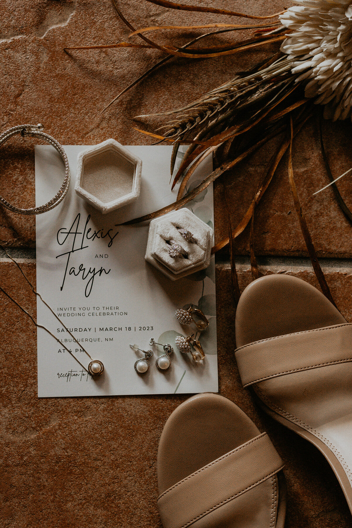 flatlay of a LGBTQ+ couples wedding details and jewelry