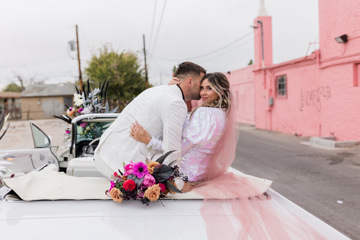 groom kisses bride in the backseat of a car