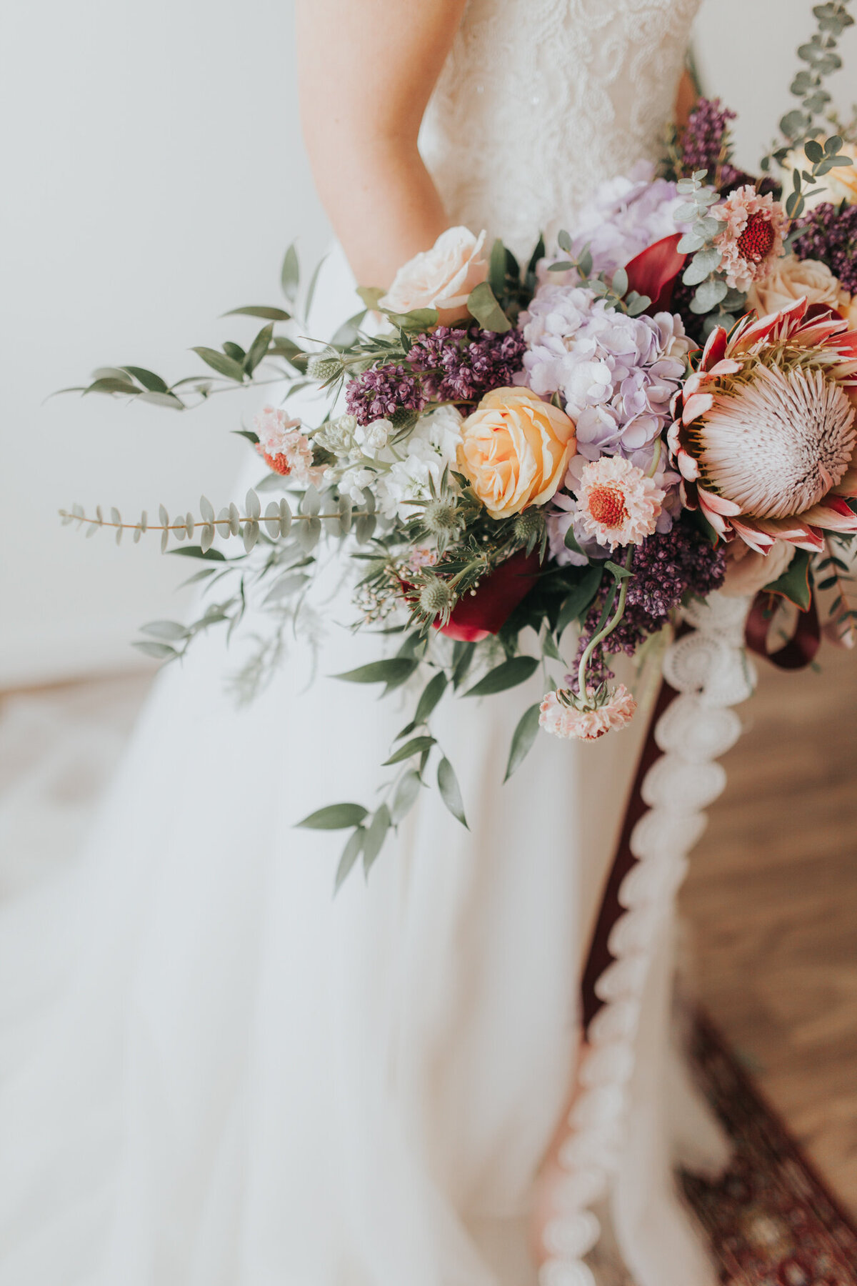 Colourful and romantic bouquet of purple and orange by The Romantiks, romantic wedding florals based in Calgary, AB & Cranbrook, BC. Featured on the Brontë Bride Vendor Guide.