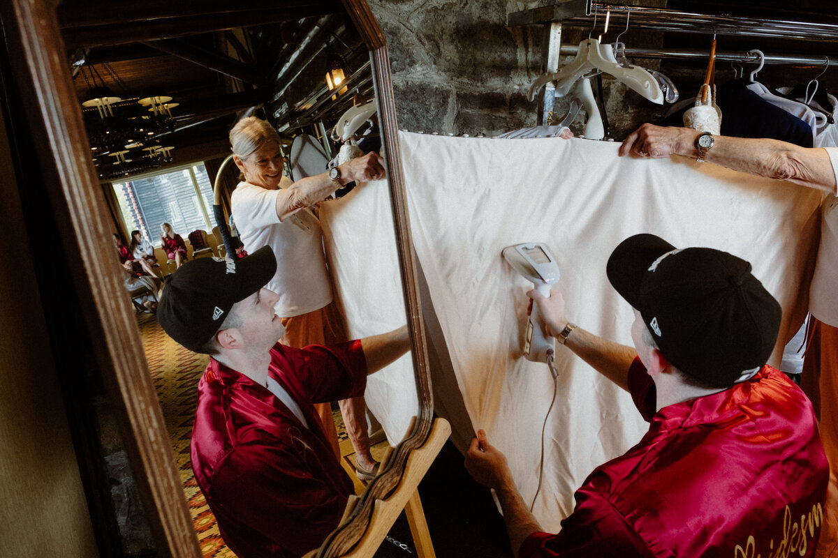 grandmother and bridesmen steaming a wedding dress 