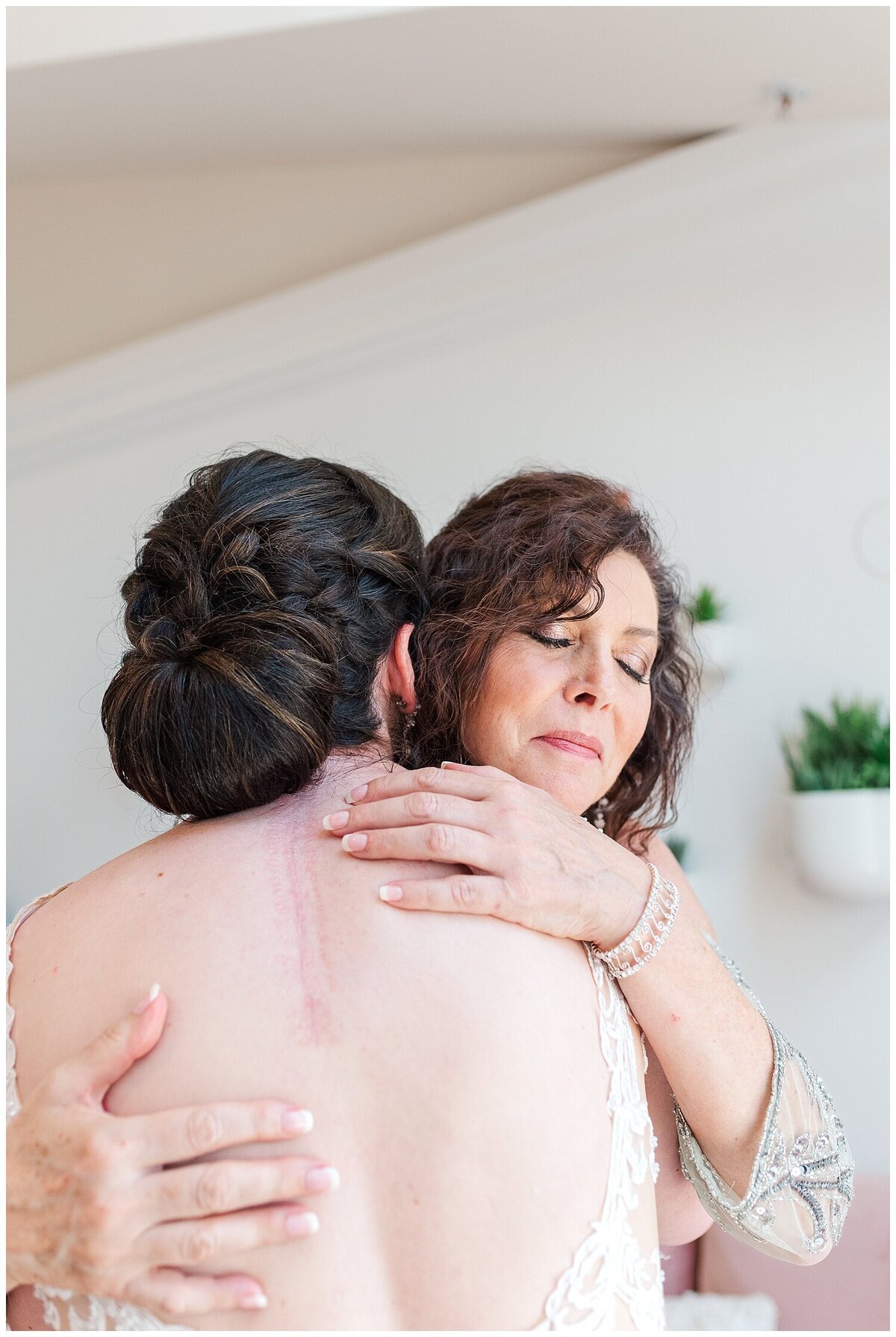 Mother of the bride hugs her daughter in the bridal suite of the chateaux at fox meadows