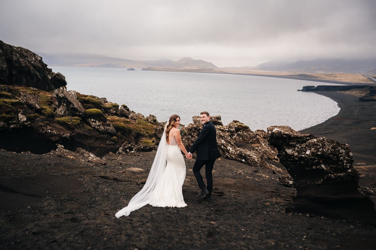Hand in hand, strolling along the Icelandic coast, this couple shares a gaze filled with love and connection.