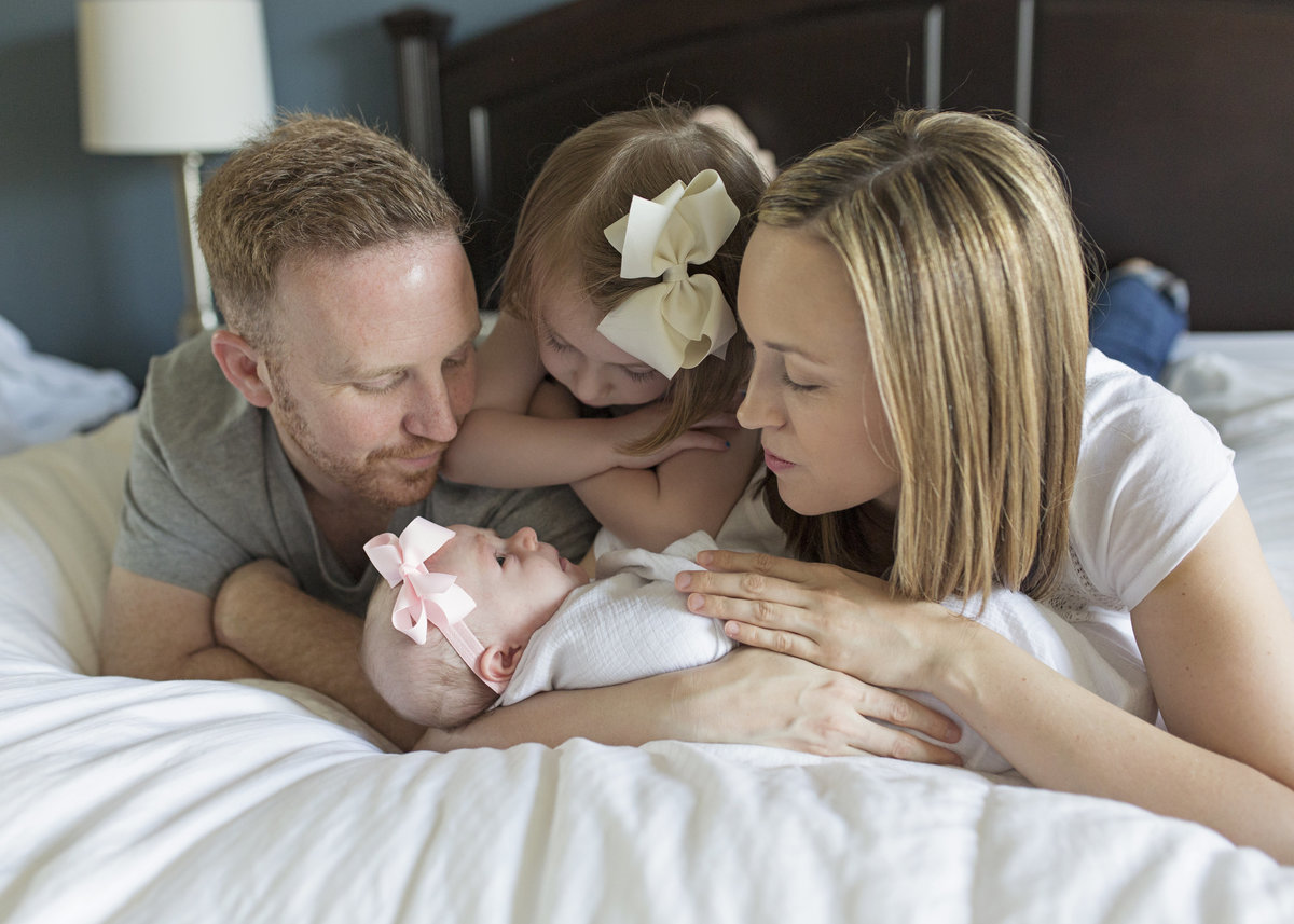charlotte family photographer captures a beautiful lifestyle portrait of family at home admiring their new baby girl