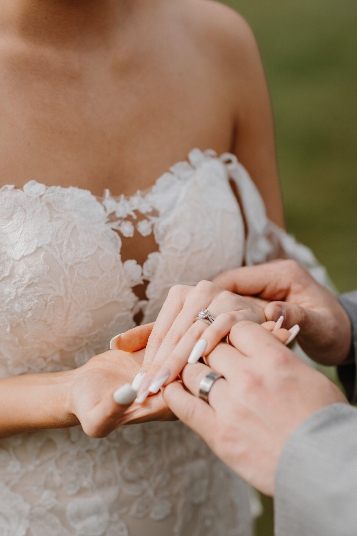 Bride and groom holding hands with wedding rings on