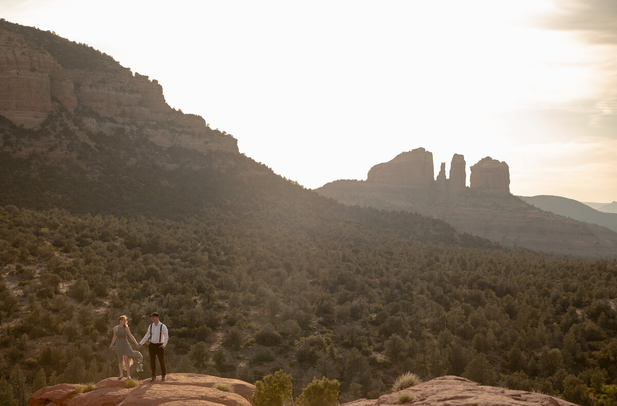 Couple standing against red rock backdrop during Sedona engagement session