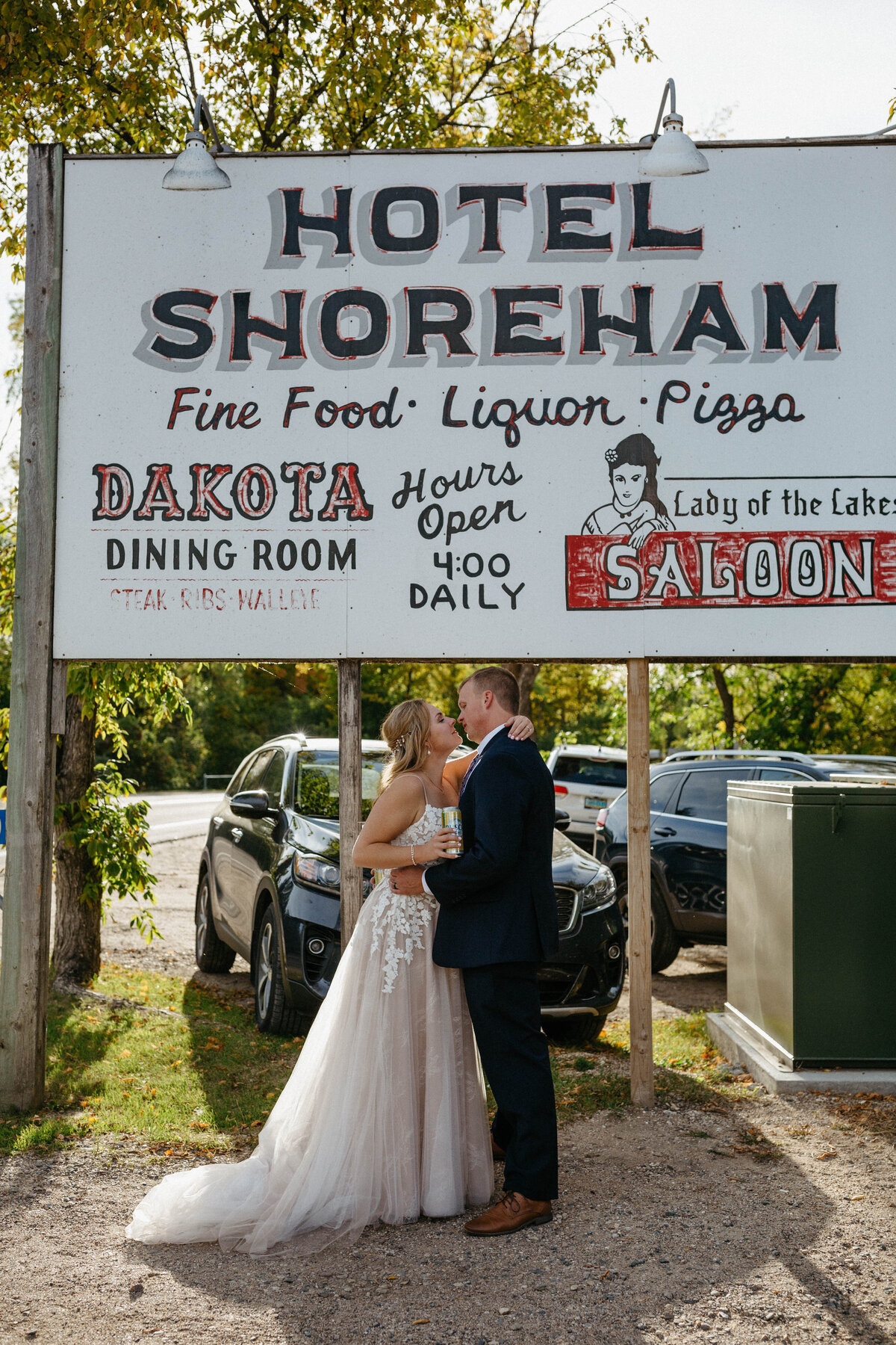 bride-and-groom-kissing-by-bar-sign