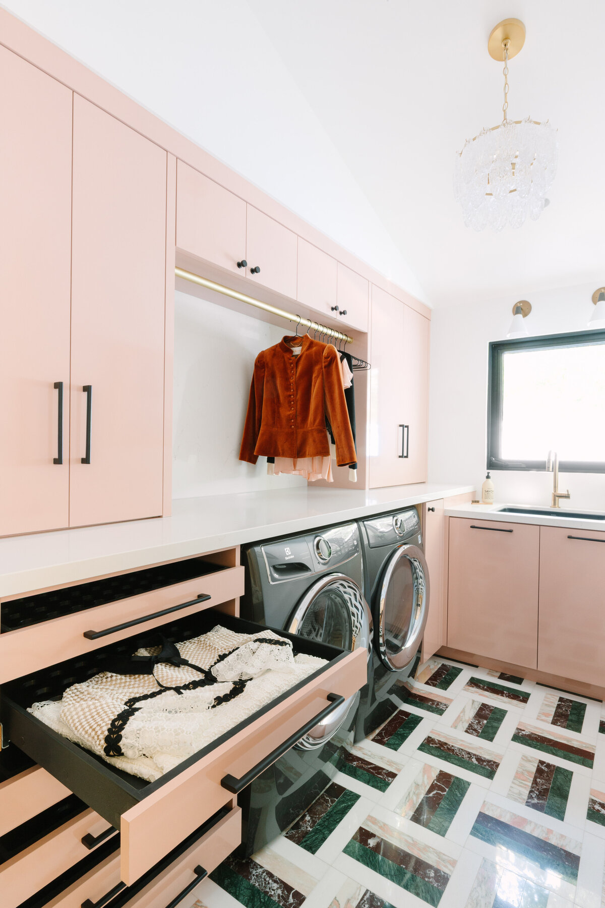 Modern Hollywood regency laundry room with pink high gloss cabinets, Caesarstone Quartz counters, and Arc Passion 12x12 Polished Marble By Elizabeth Sutton: Pattern 12 flooring with pink, green and burgundy marble. Drawer drying racks.