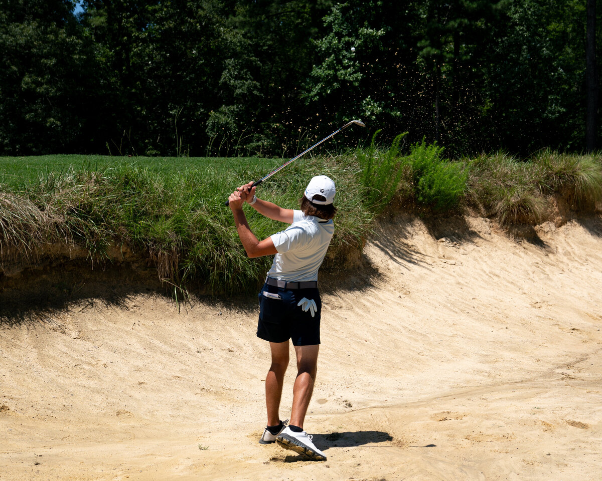 Backside photo of golfer hitting ball out of bunker at Tobacco Road in Sanford, NC