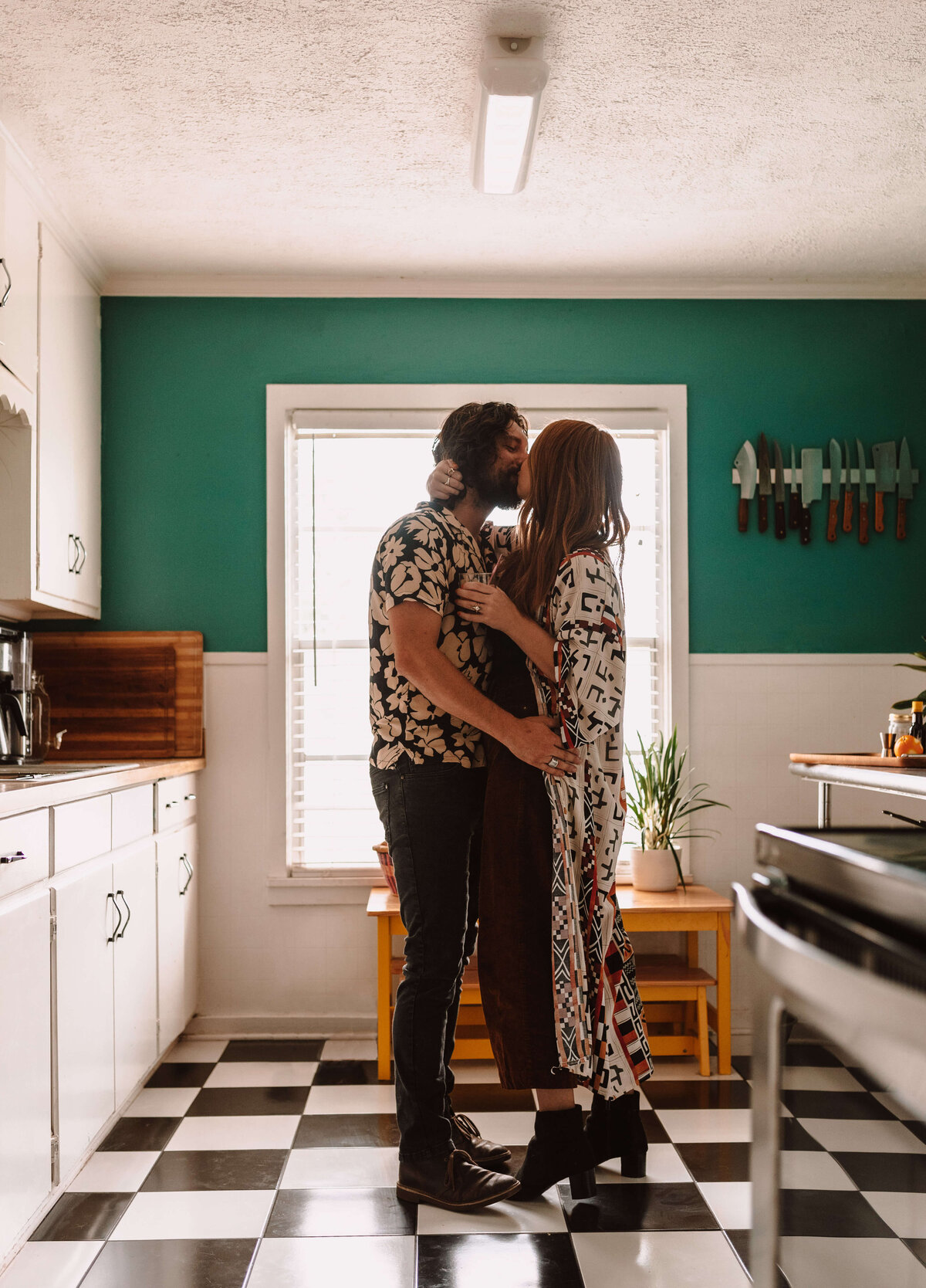 engaged couple dance & kiss in vintage kitchen in cove home