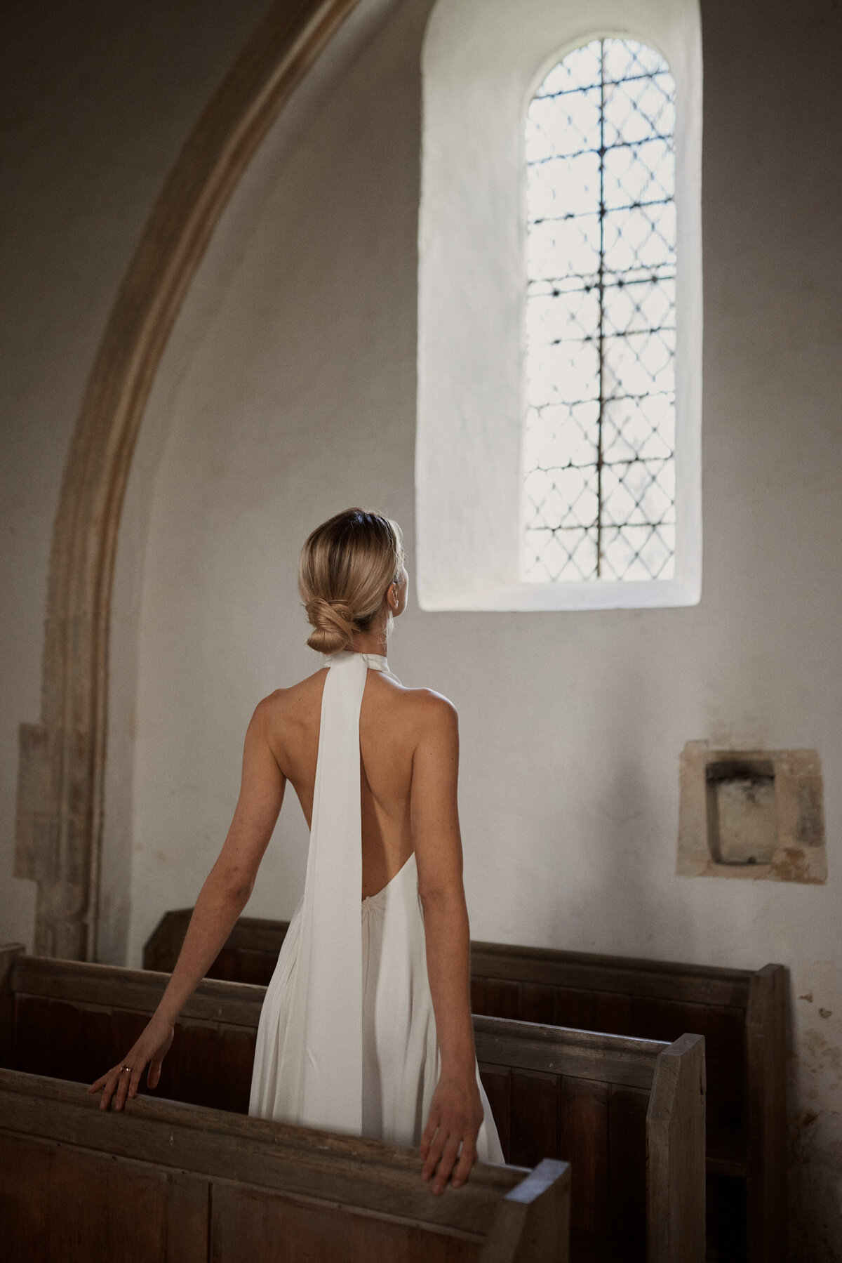 Backless sleeveless high neck wedding dress, pure silk fabric on bride in church pews