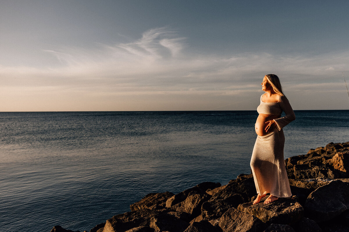 Pregnancy maternity photography shoot at Mornington Penninsula beach - lady stands on rocks